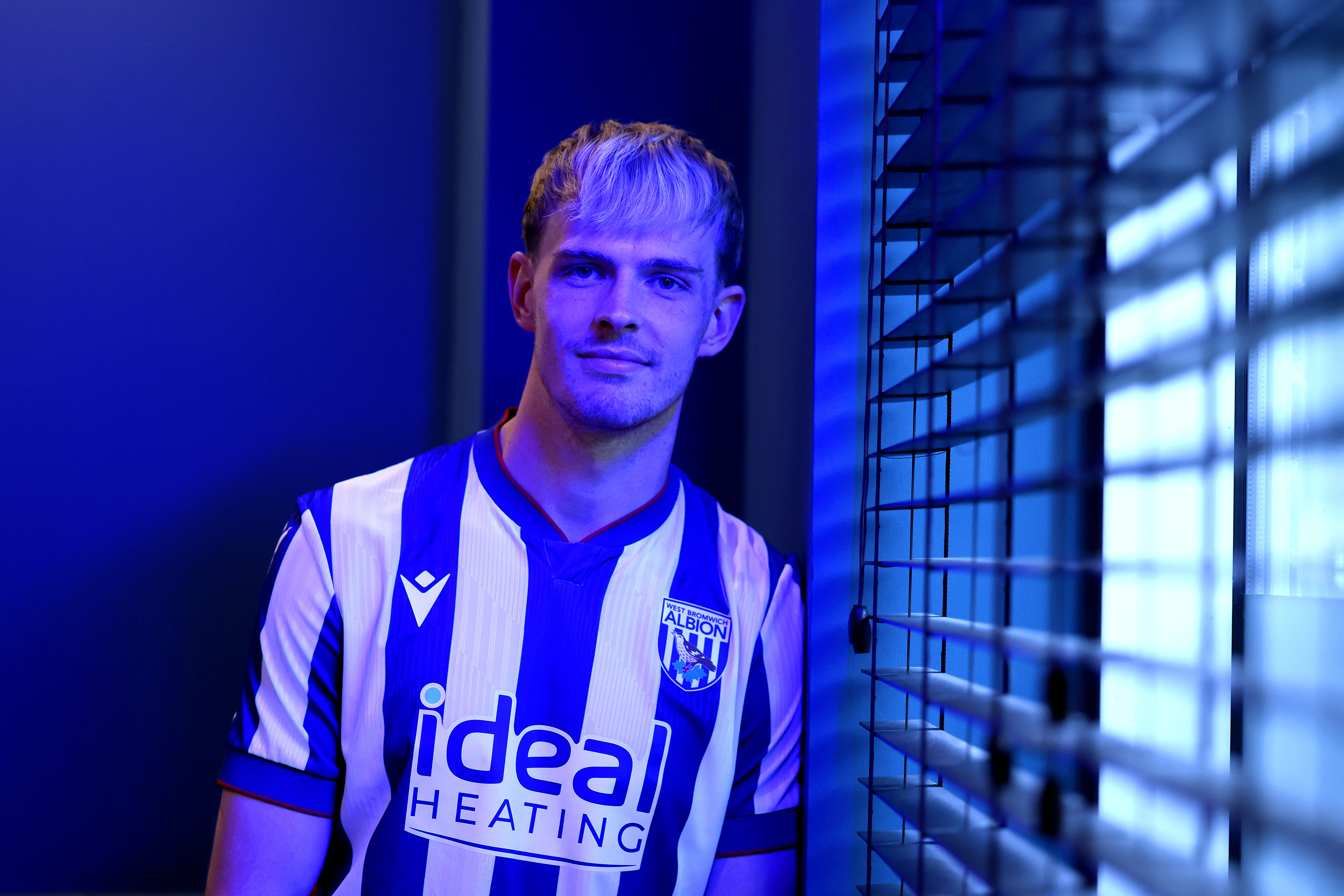 Toby Collyer poses in blue lighting