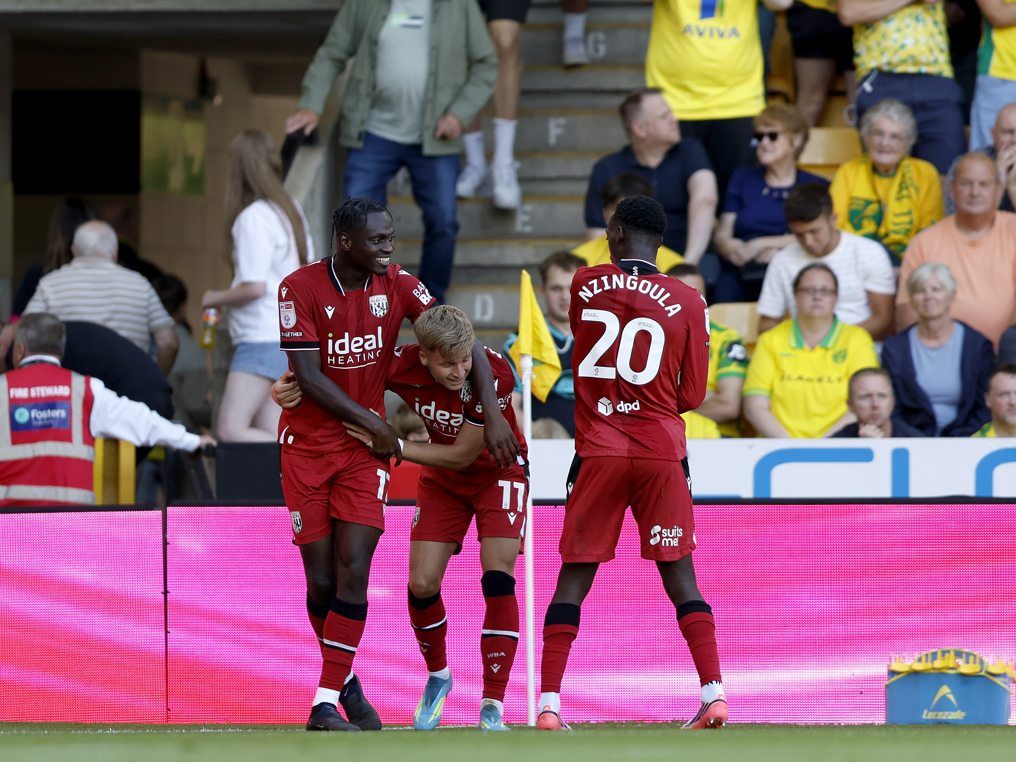 JJ Morgan celebrates with Ousmane Diakité and Rabby Nzingoula after his goal at Norwich in the red away kit 