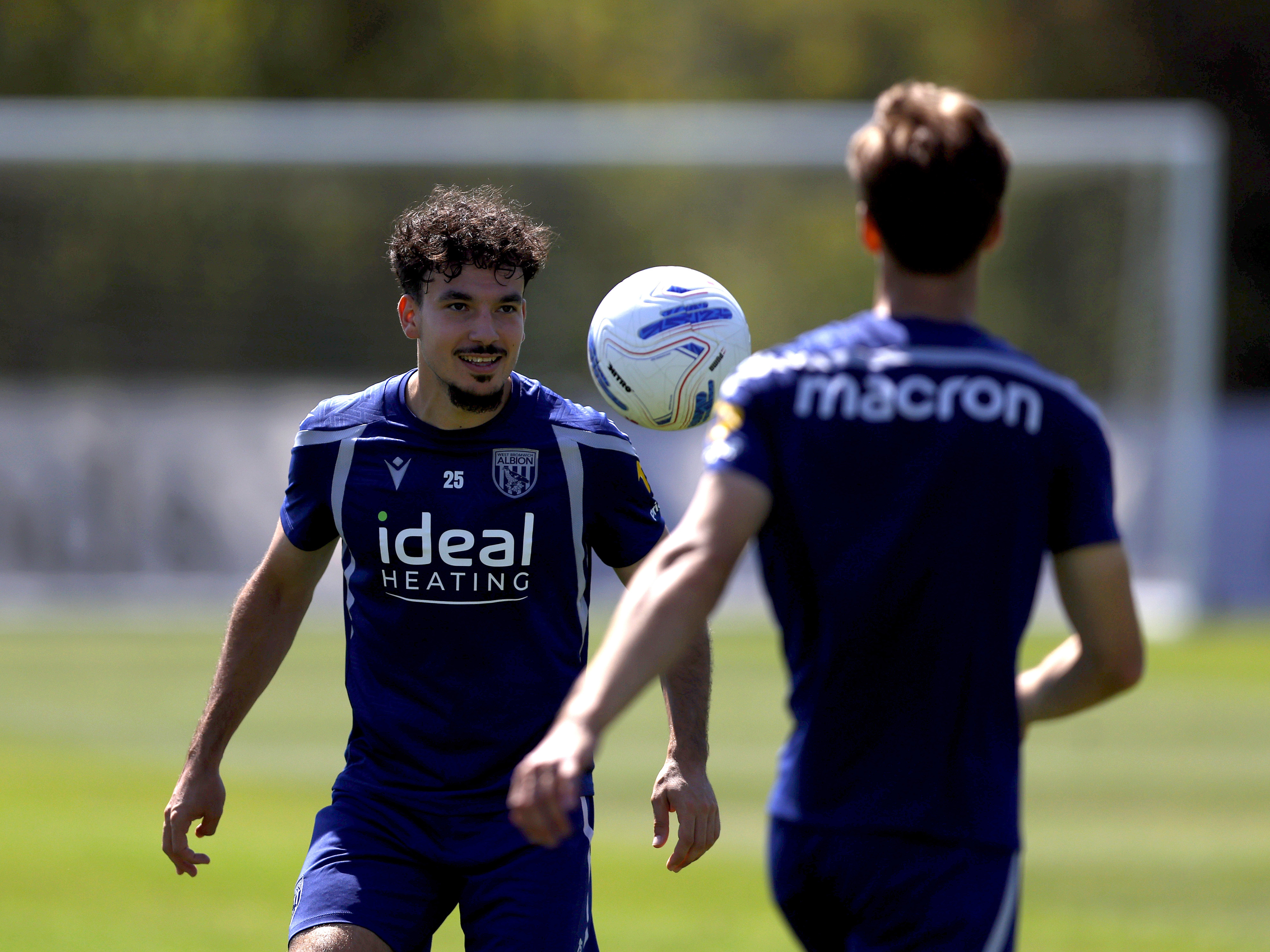 Nolan Galves smiling while watching the ball in mid-air during a training session