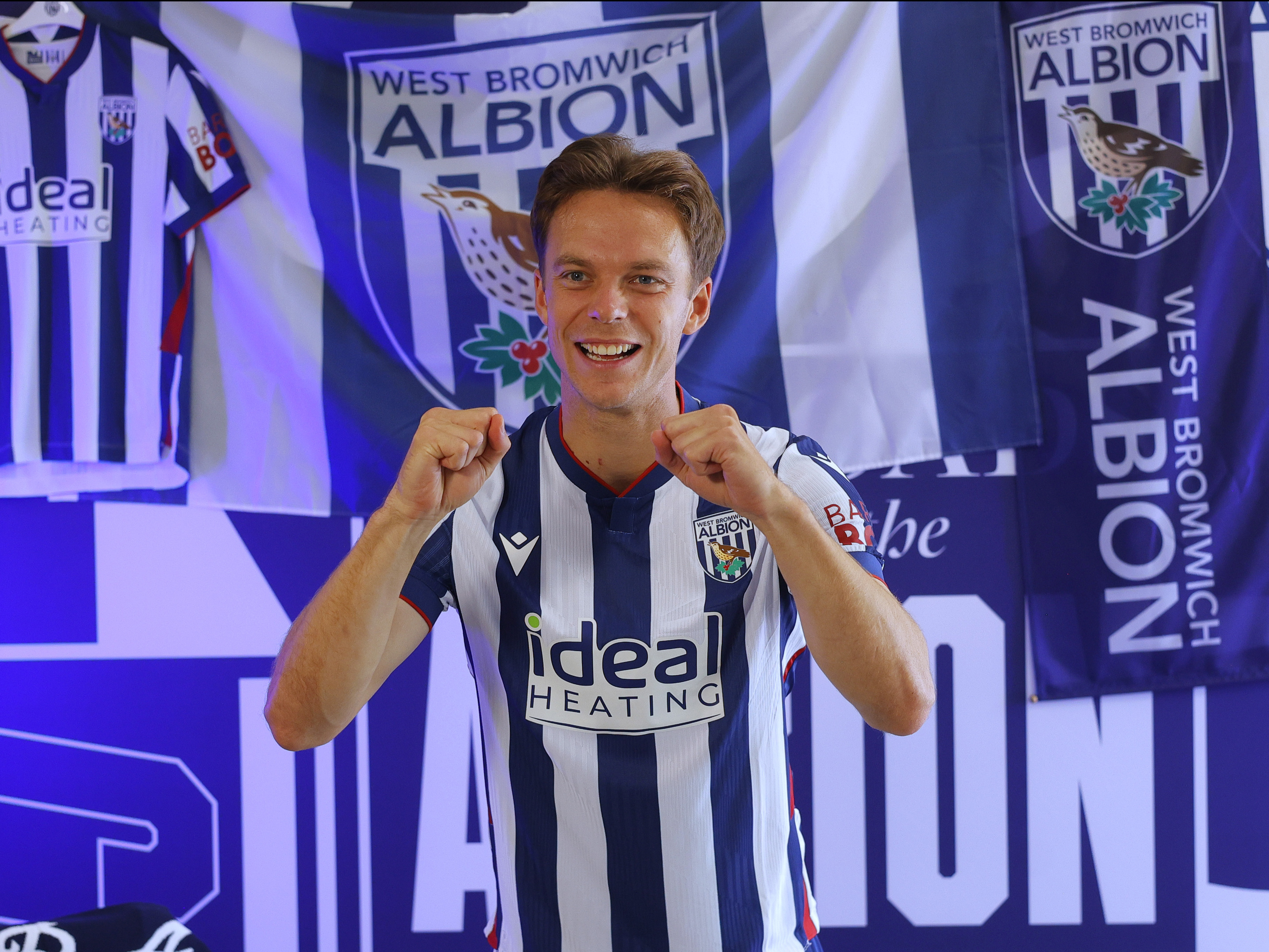 Felix Horn Myhre celebrating towards the camera while stood in the home kit in front of WBA branding 