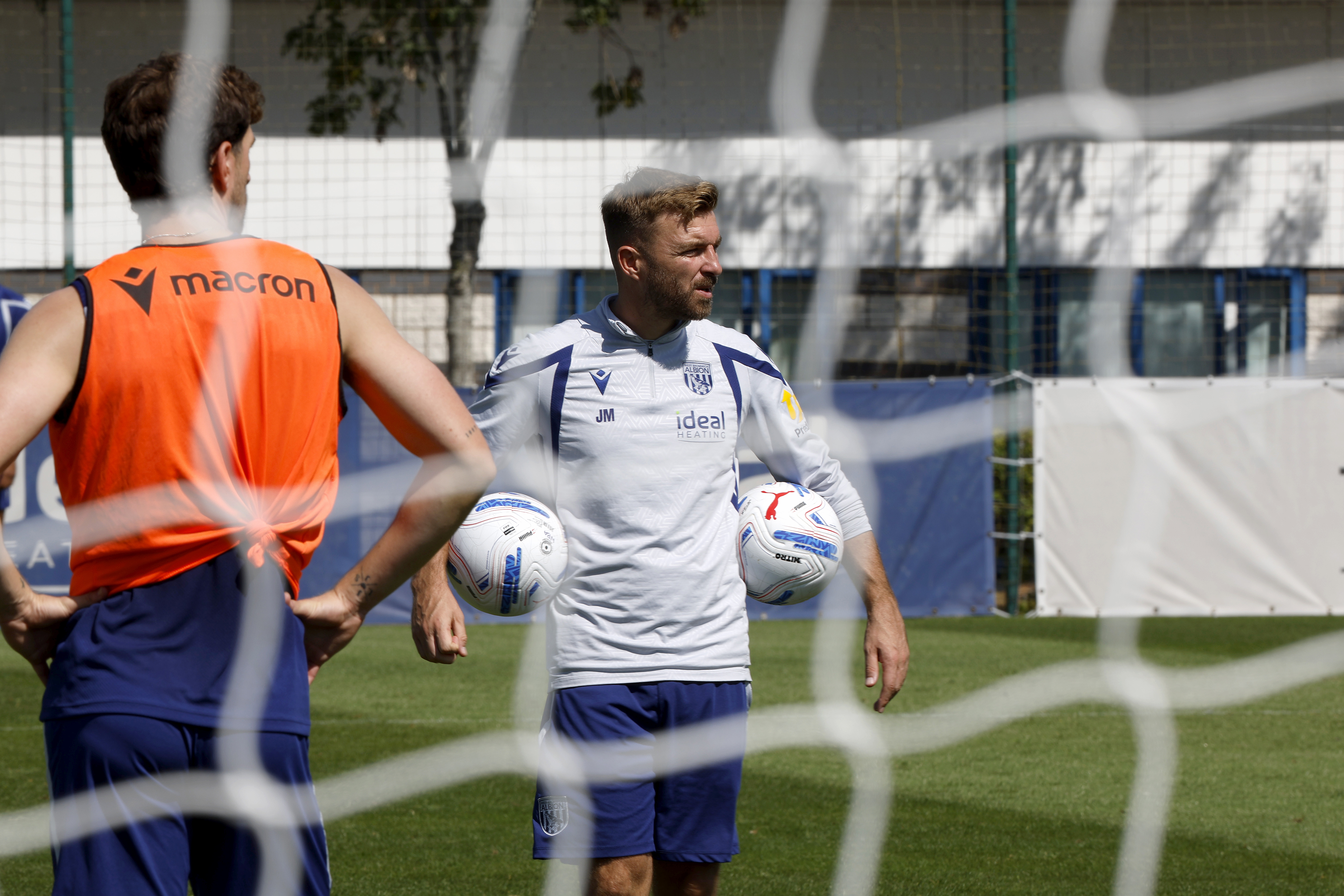 James Morrison holding two footballs during a training session