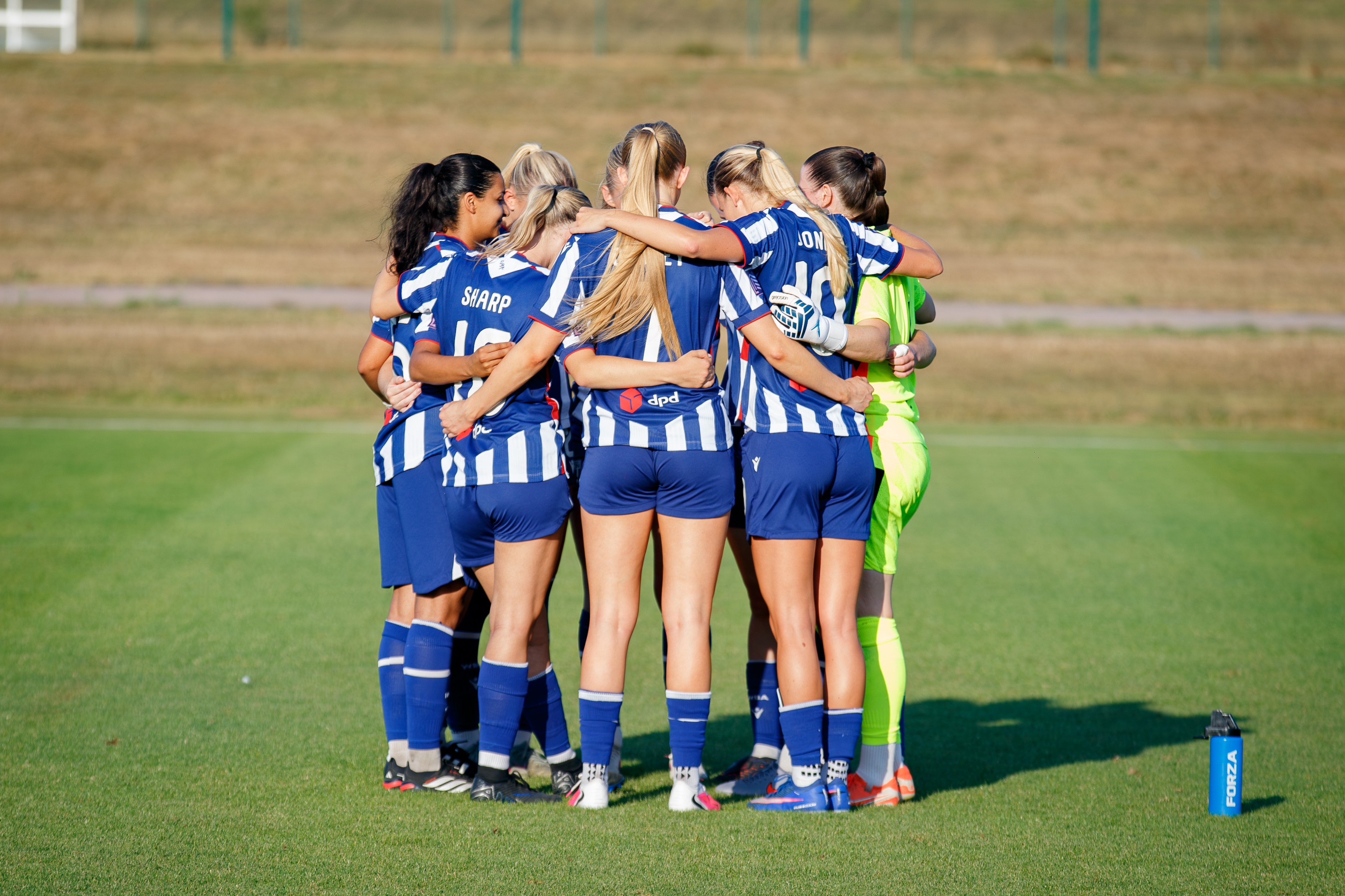 Albion Women in a team huddle.