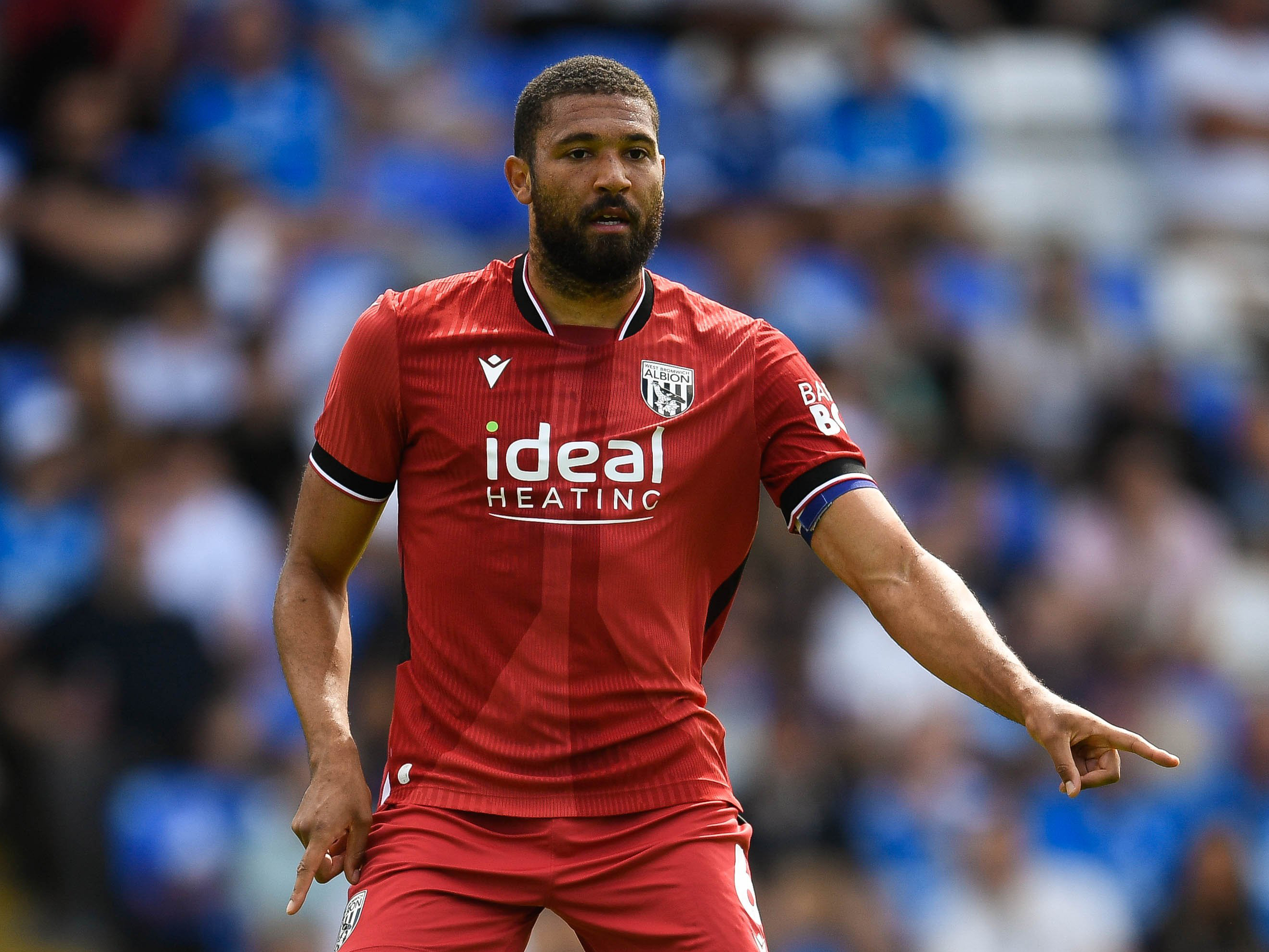 George Campbell in action in the red away kit wearing the armband 