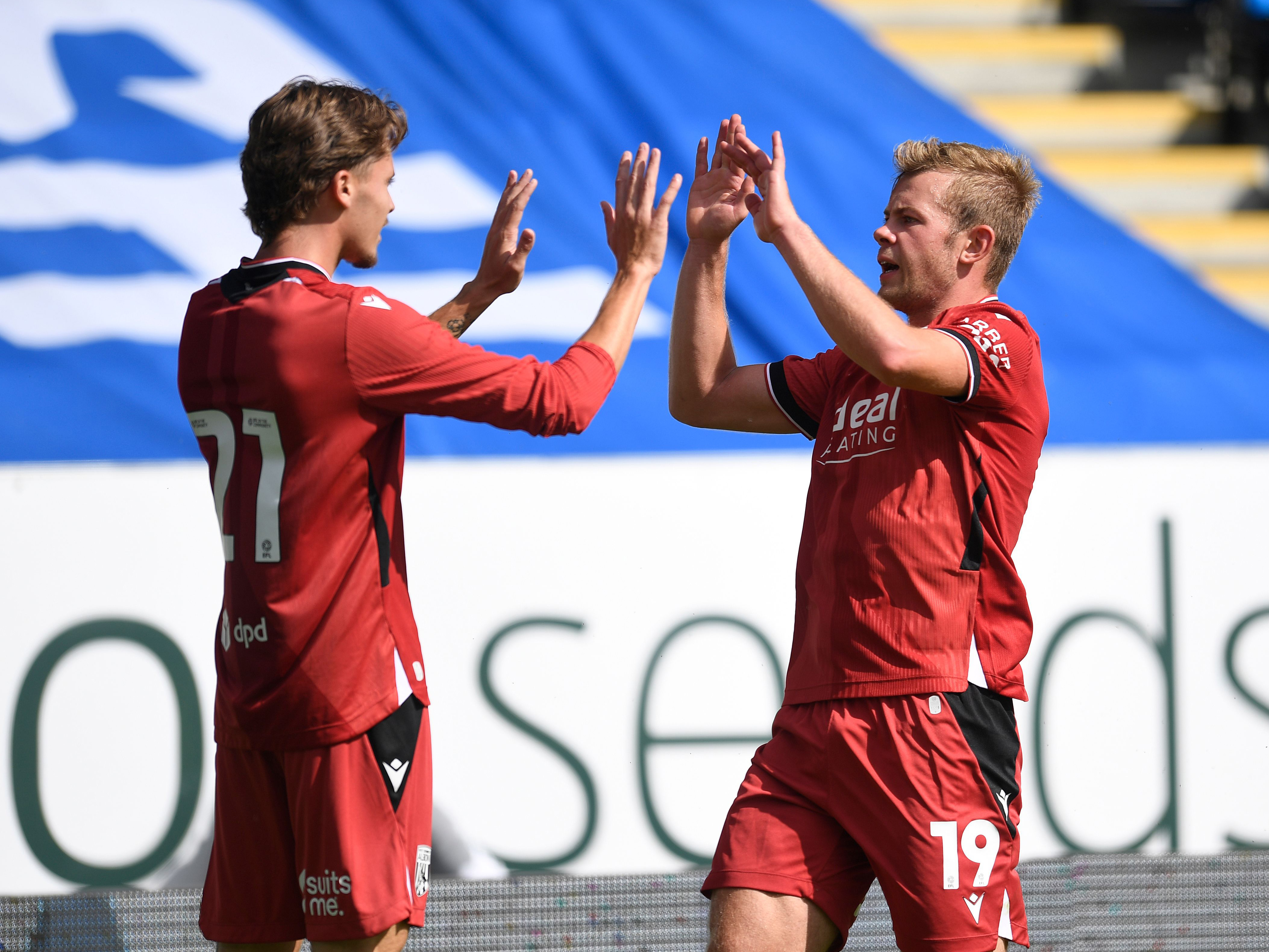 Isaac Price and Aune Heggebø high-fiving in the red away kit 