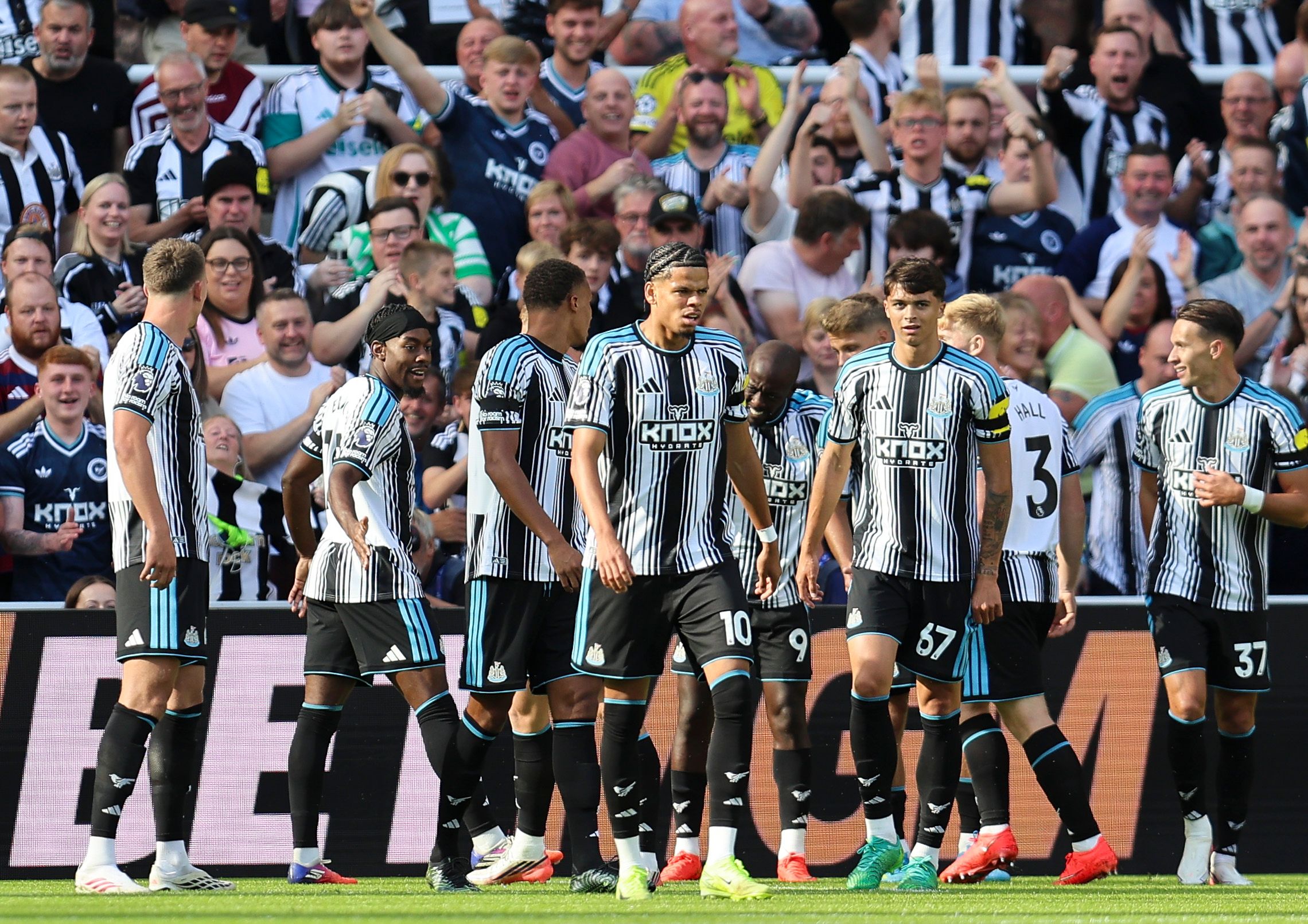 Newcastle players celebrate together in the home kit after scoring against Newcastle 
