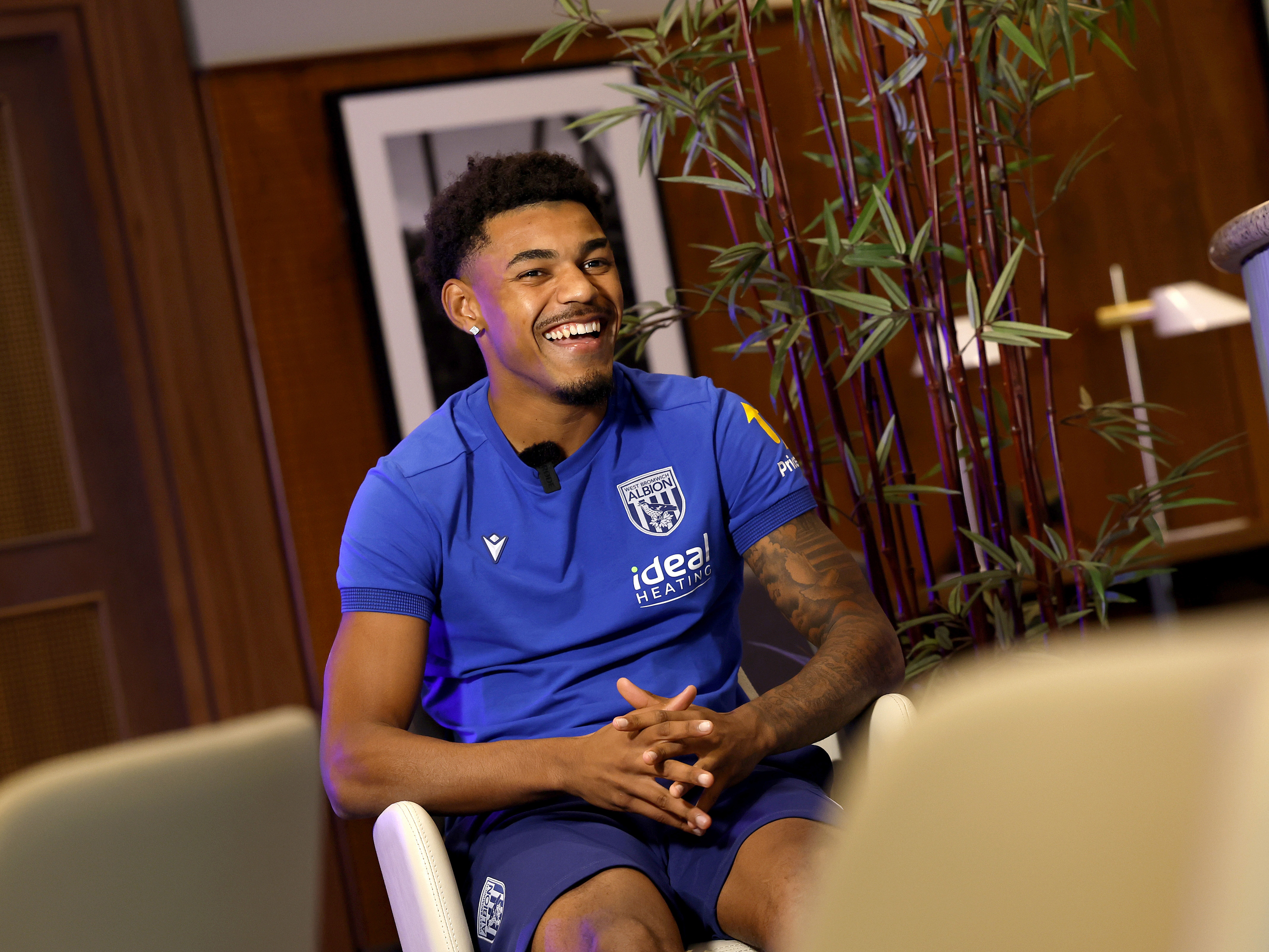 Kareem Tunde smiling while sat in a chair 