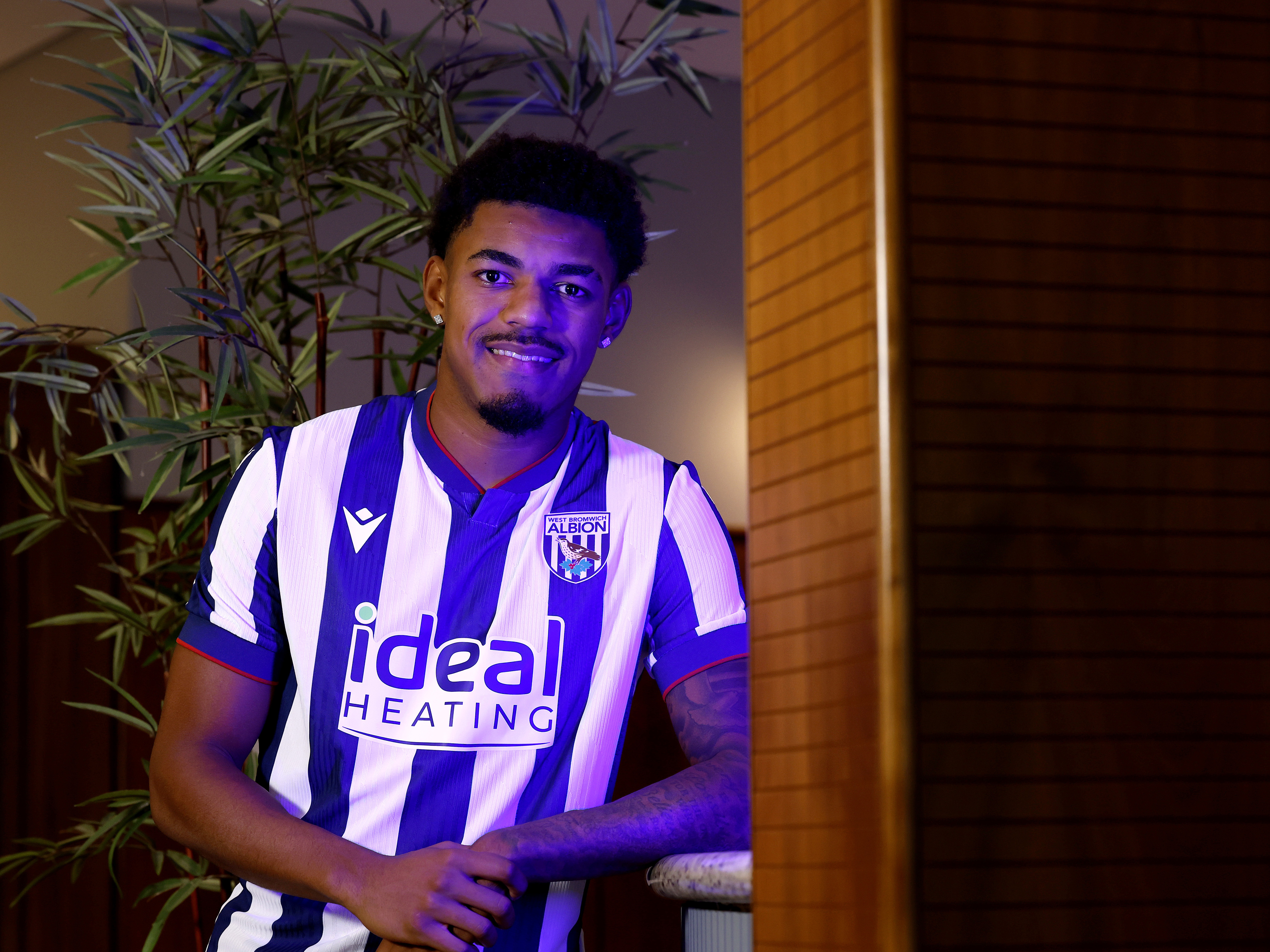 Kareem Tunde smiling at the camera while stood in a WBA home shirt 