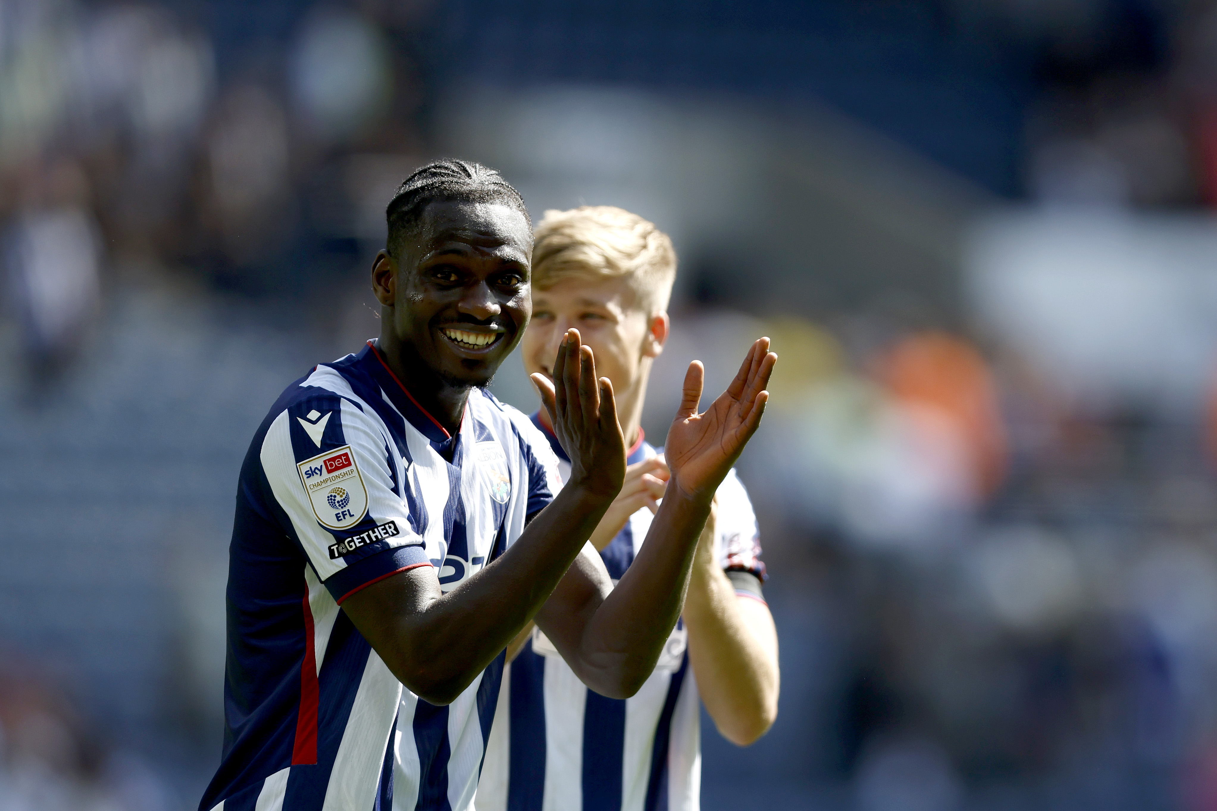 Ousmane Diakite smiles while applauding the home fans
