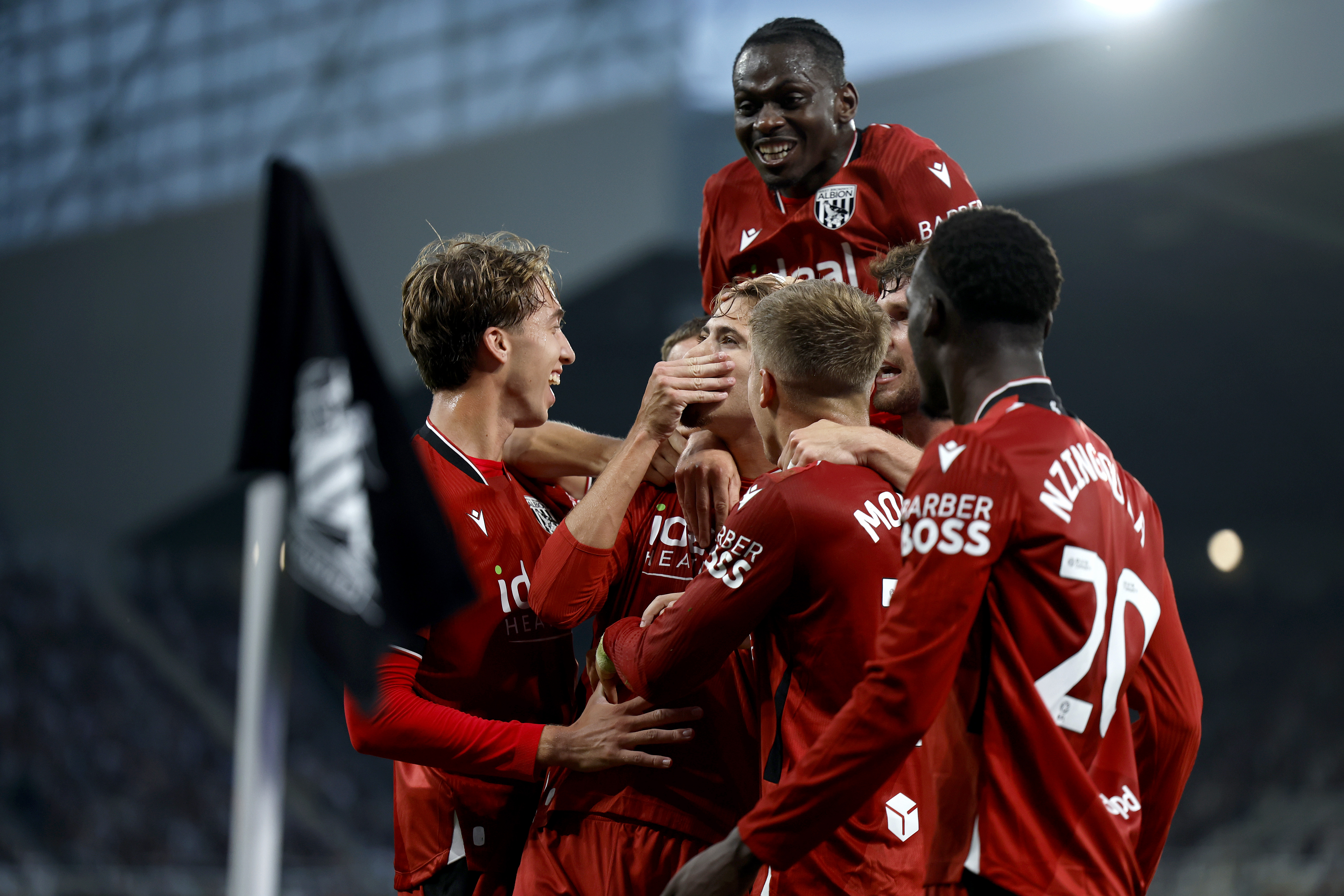 Isaac Price celebrates with team-mates after scoring at Newcastle in the red away kit 