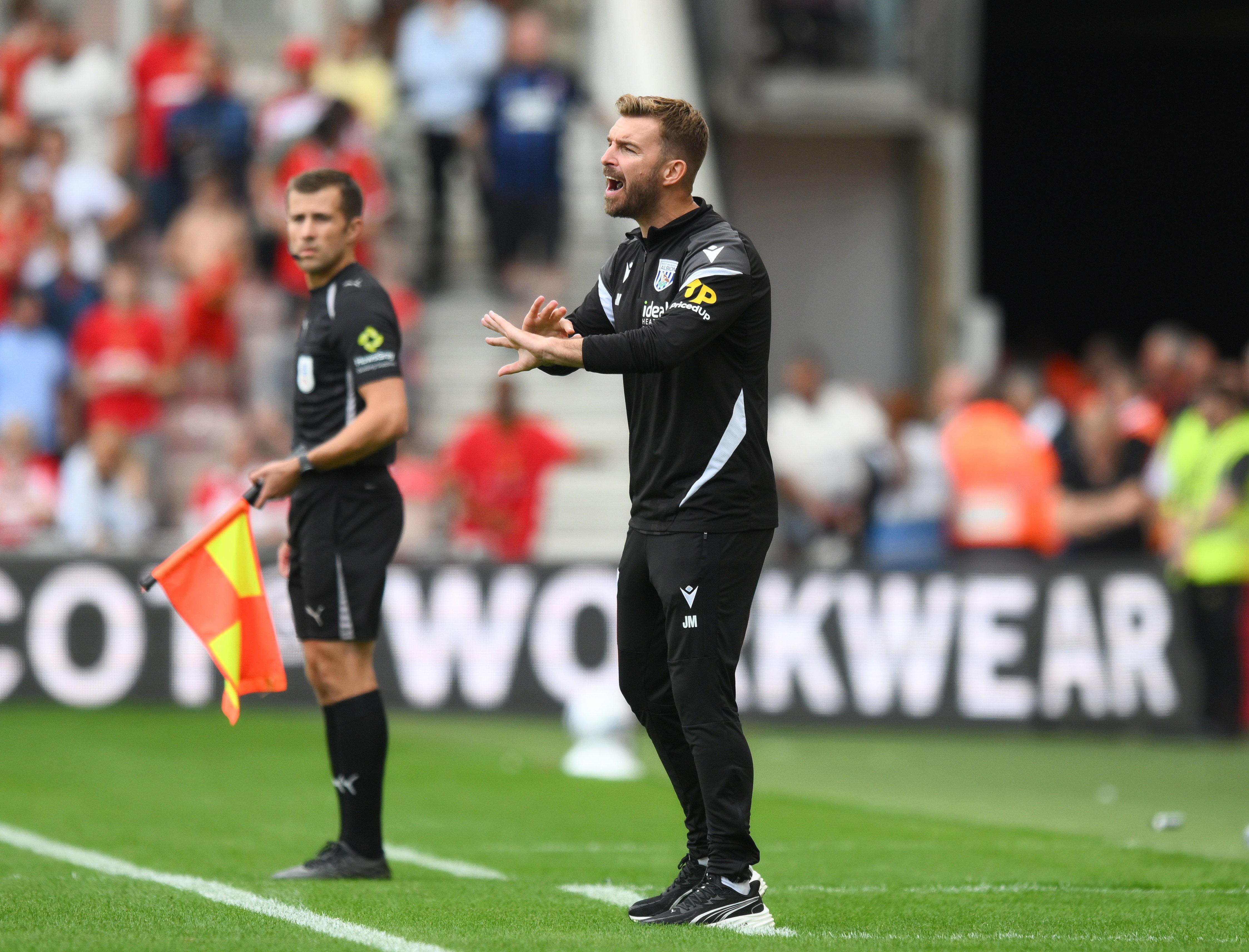 James Morrison shouting instructions at players on the side of the pitch 