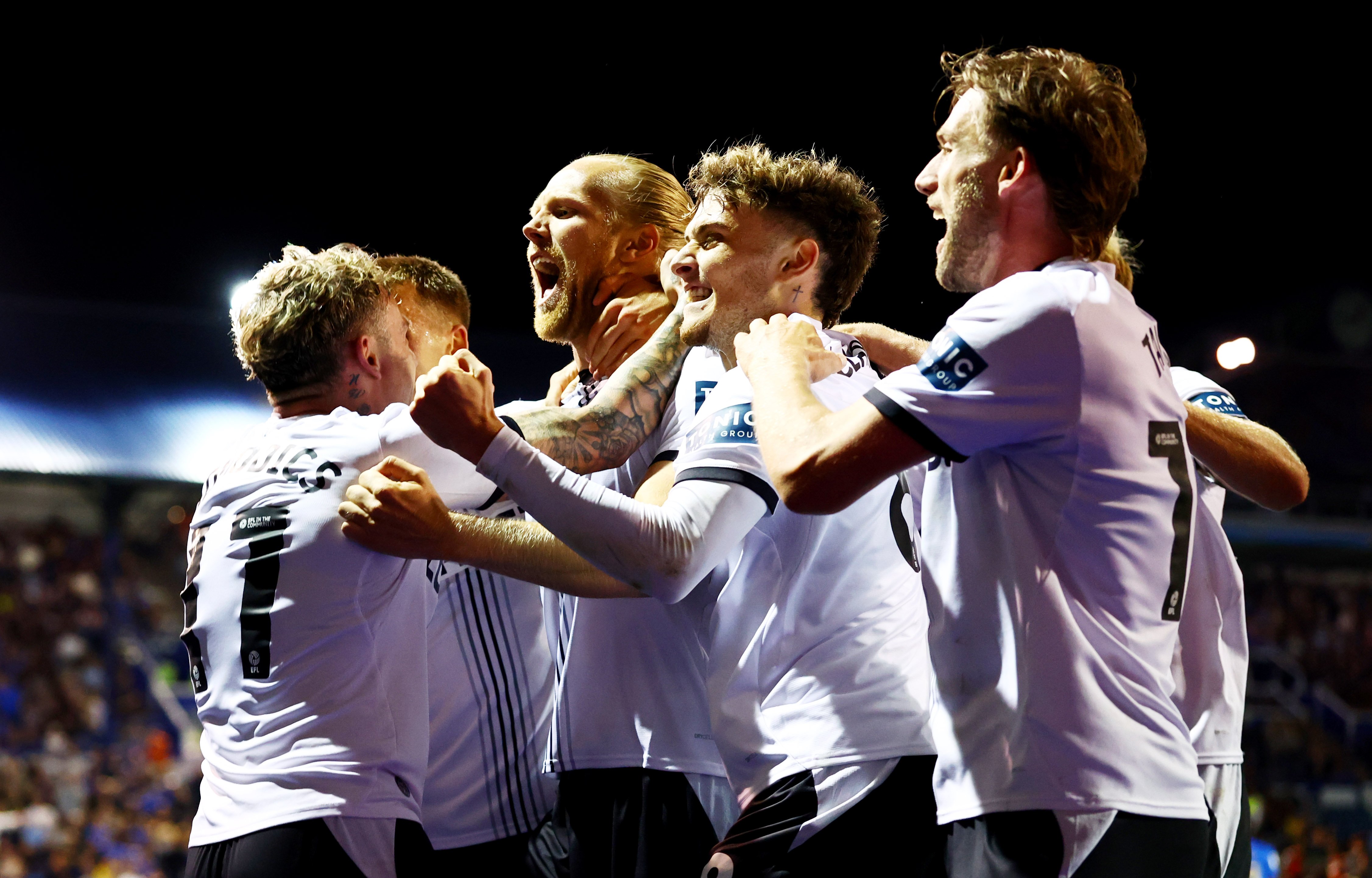 Several Derby players celebrate a goal scored at Portsmouth in the home kit