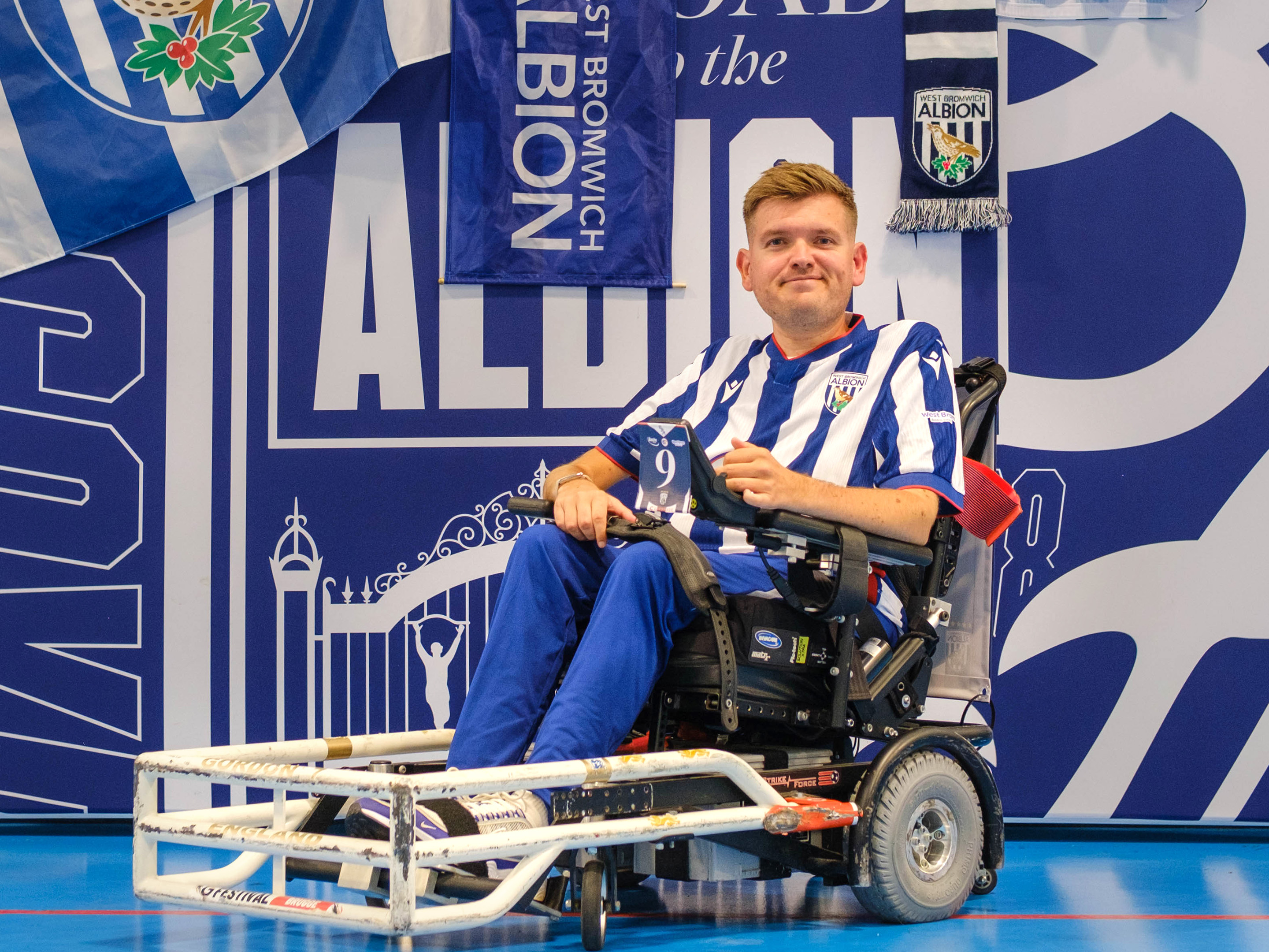 Chris Gordon seating in his chair with WBA Branding backdrop behind him.
