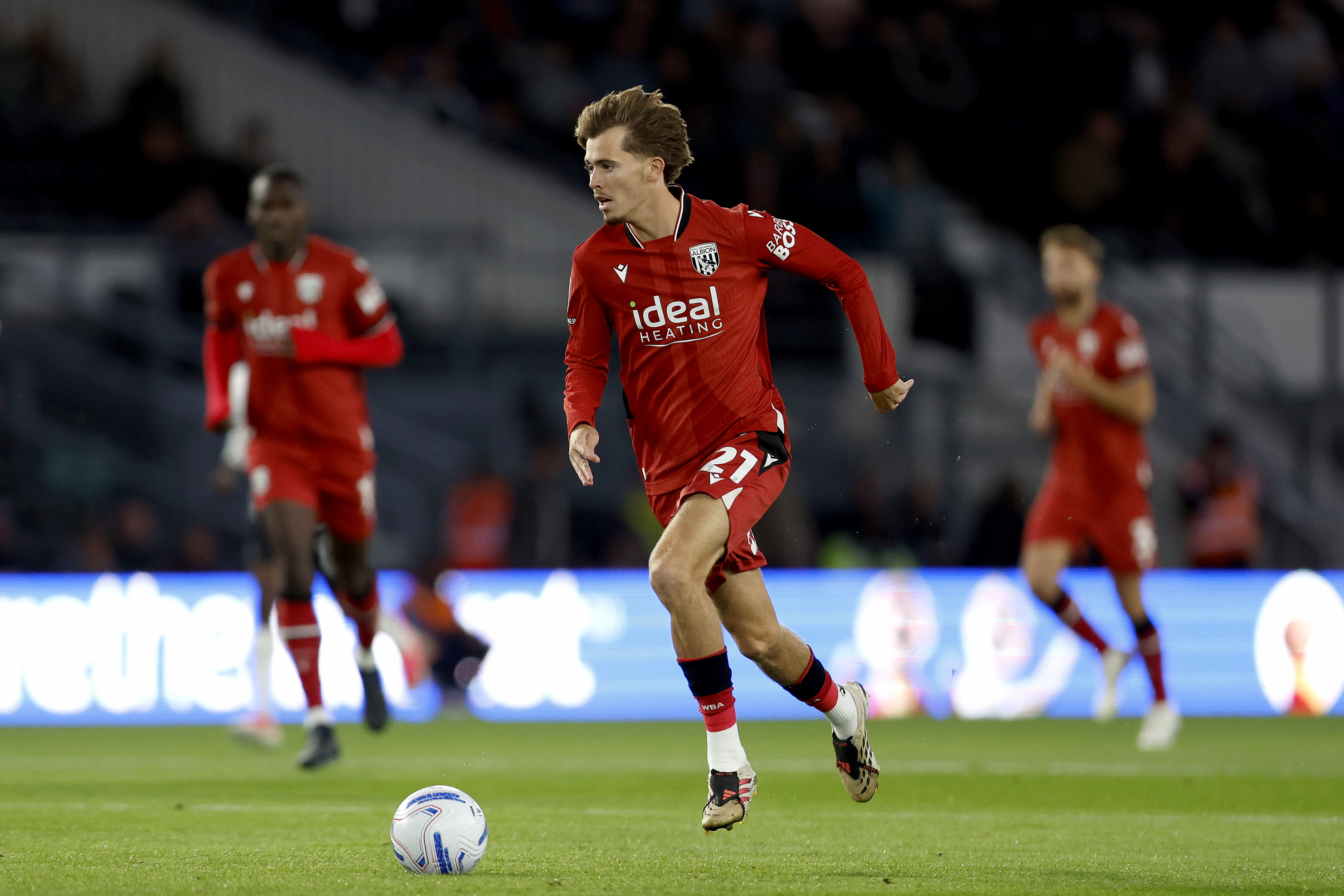 Isaac Price running with the ball against Derby in the red kit 