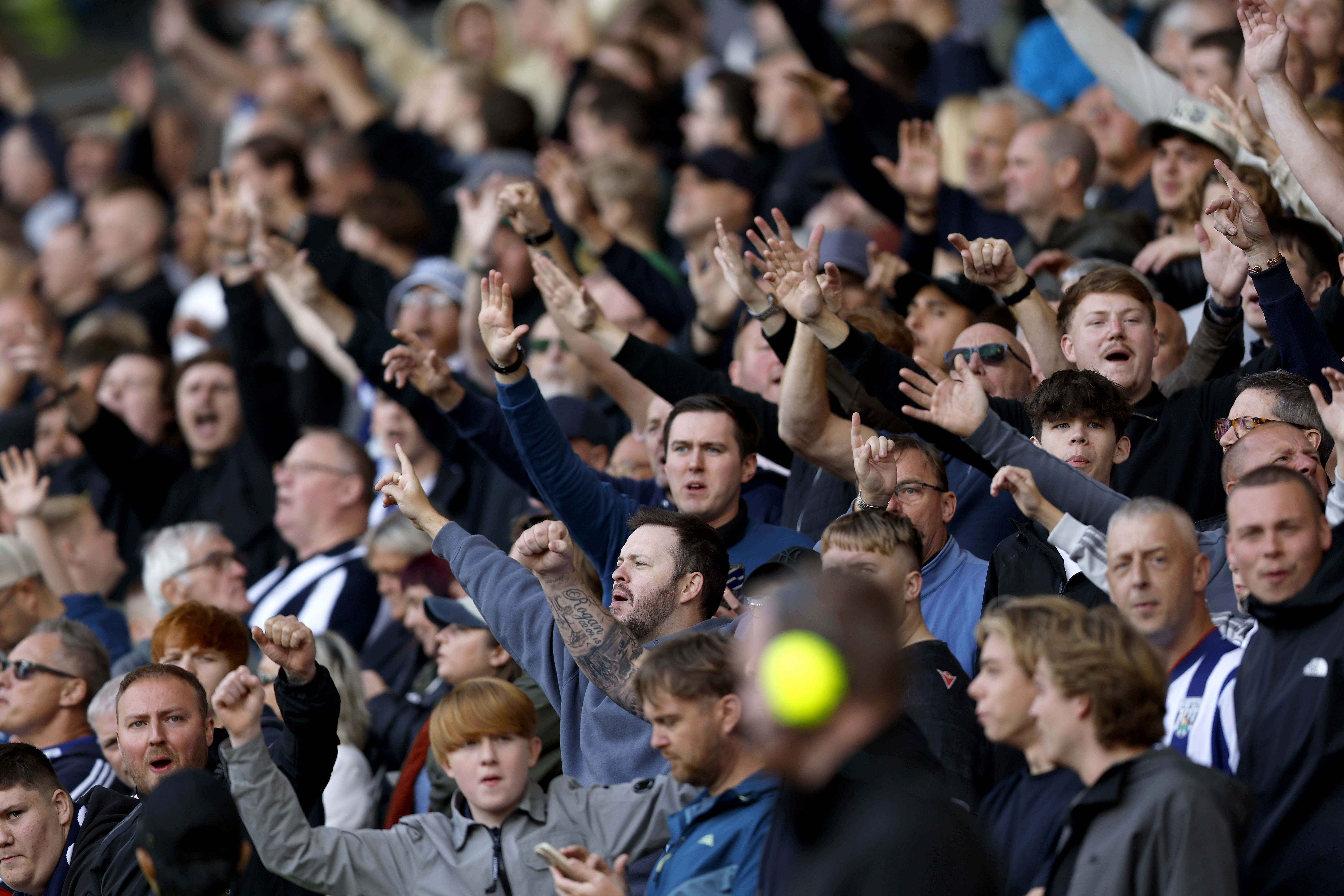 A general view of several WBA fans cheering in the stand at a game