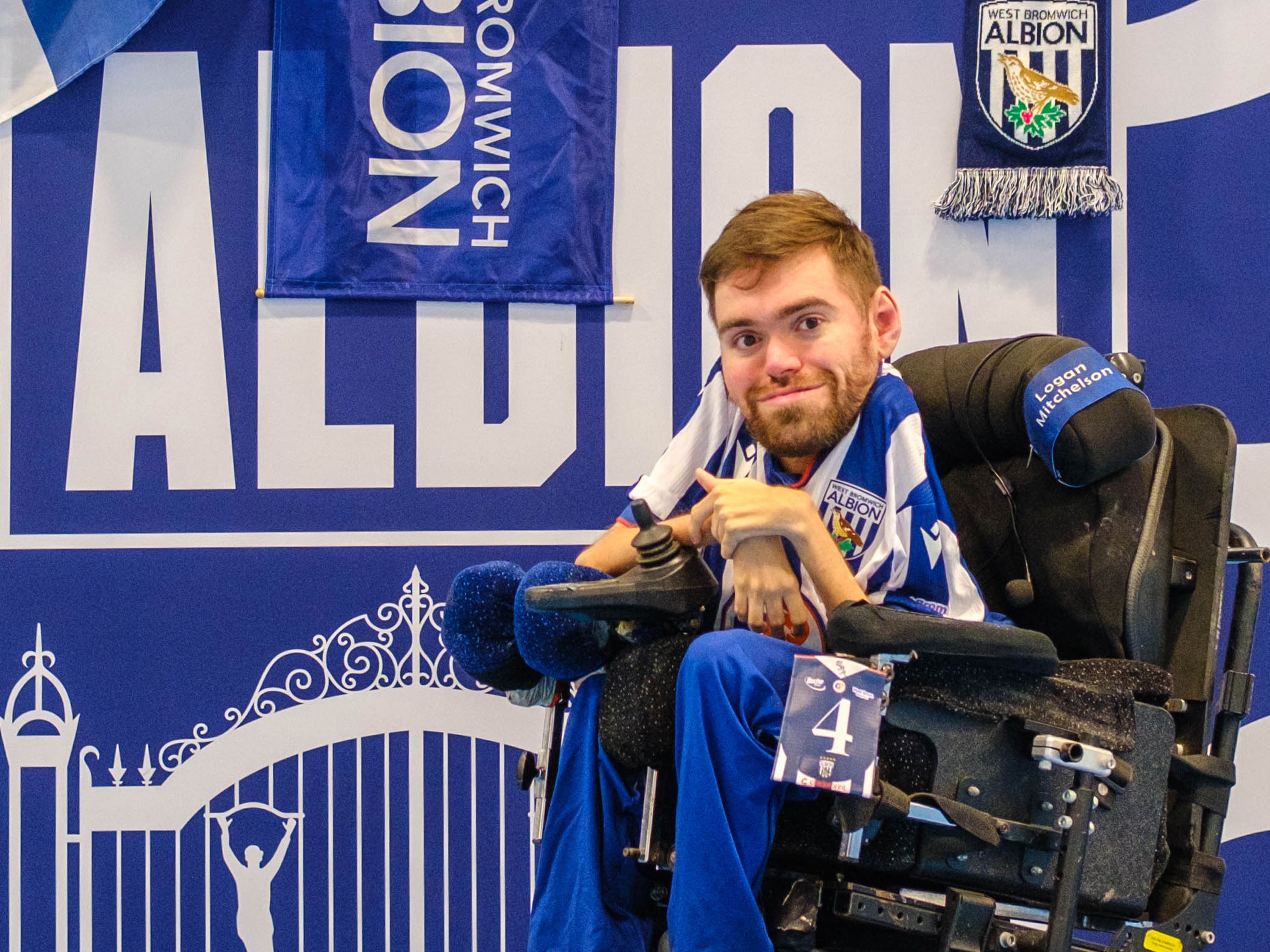 Marcus Harrison seating in his chair with WBA Branding backdrop behind him.