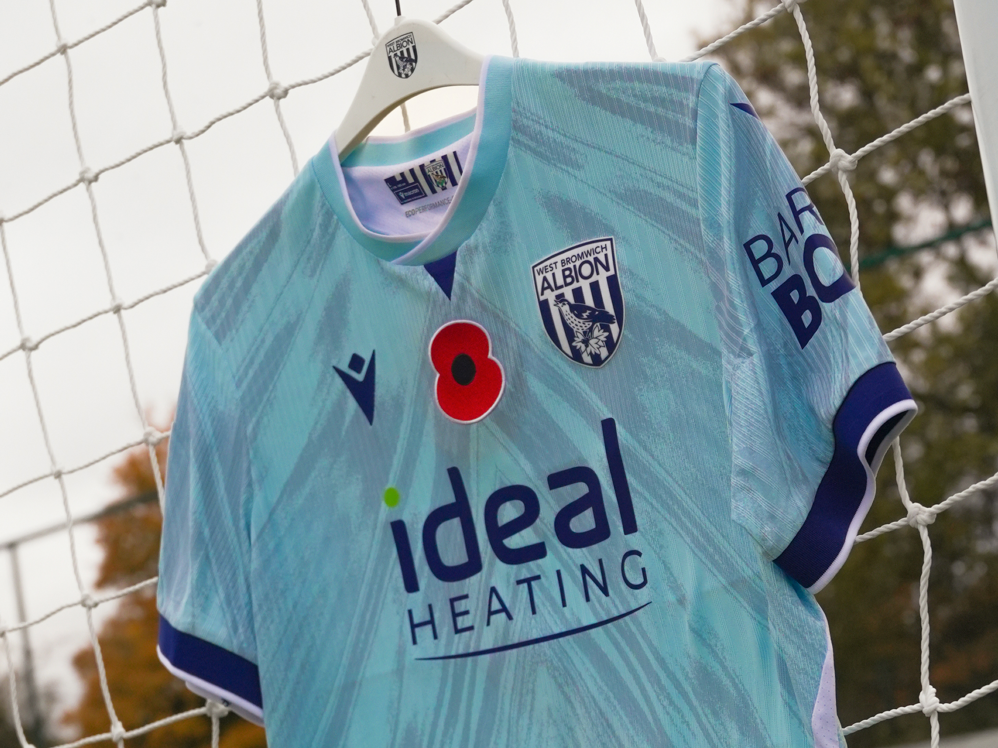 WBA's blue third shirt hanging on a goal net with a poppy on it