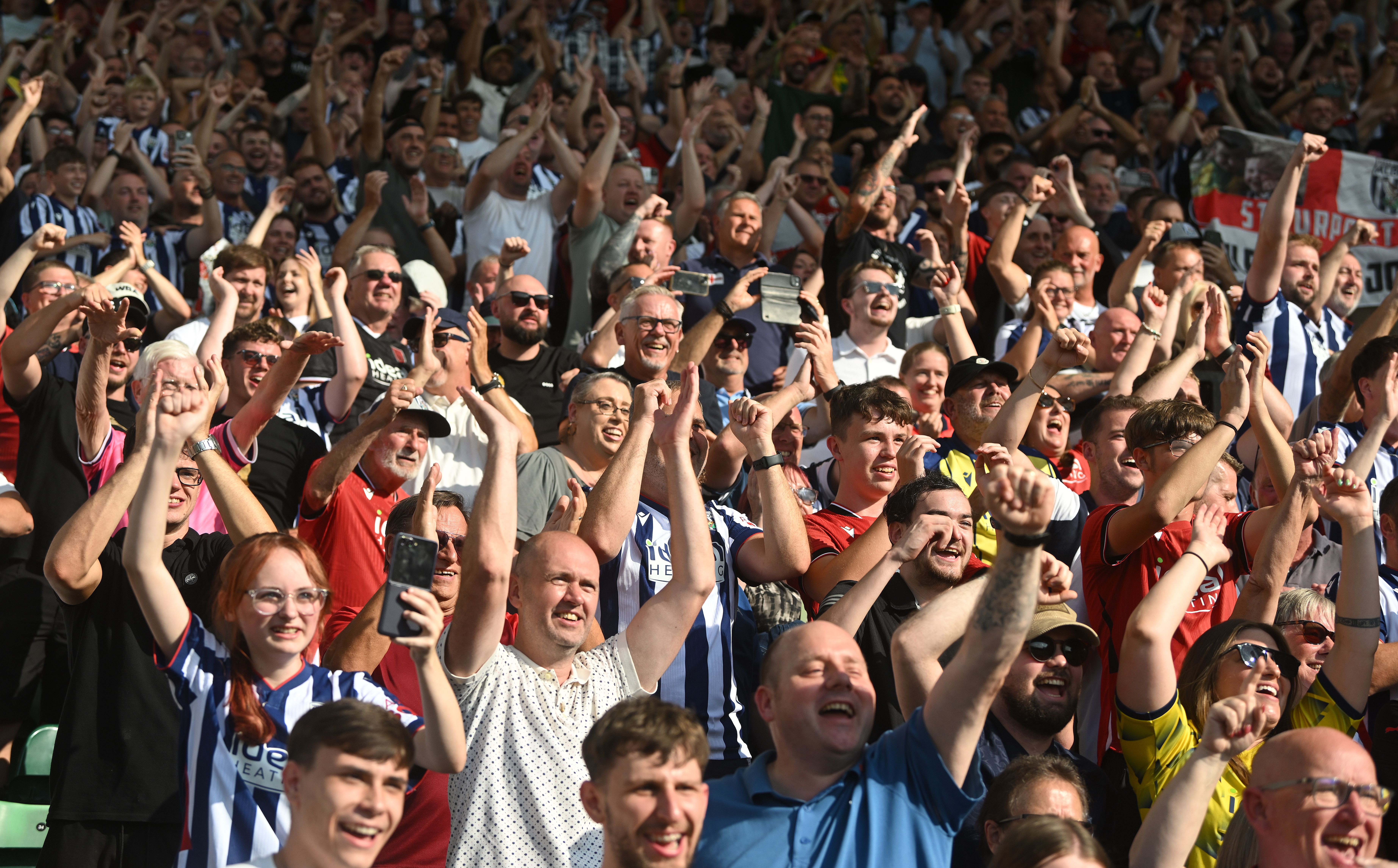 A general view of several WBA fans cheering in the stands at a game