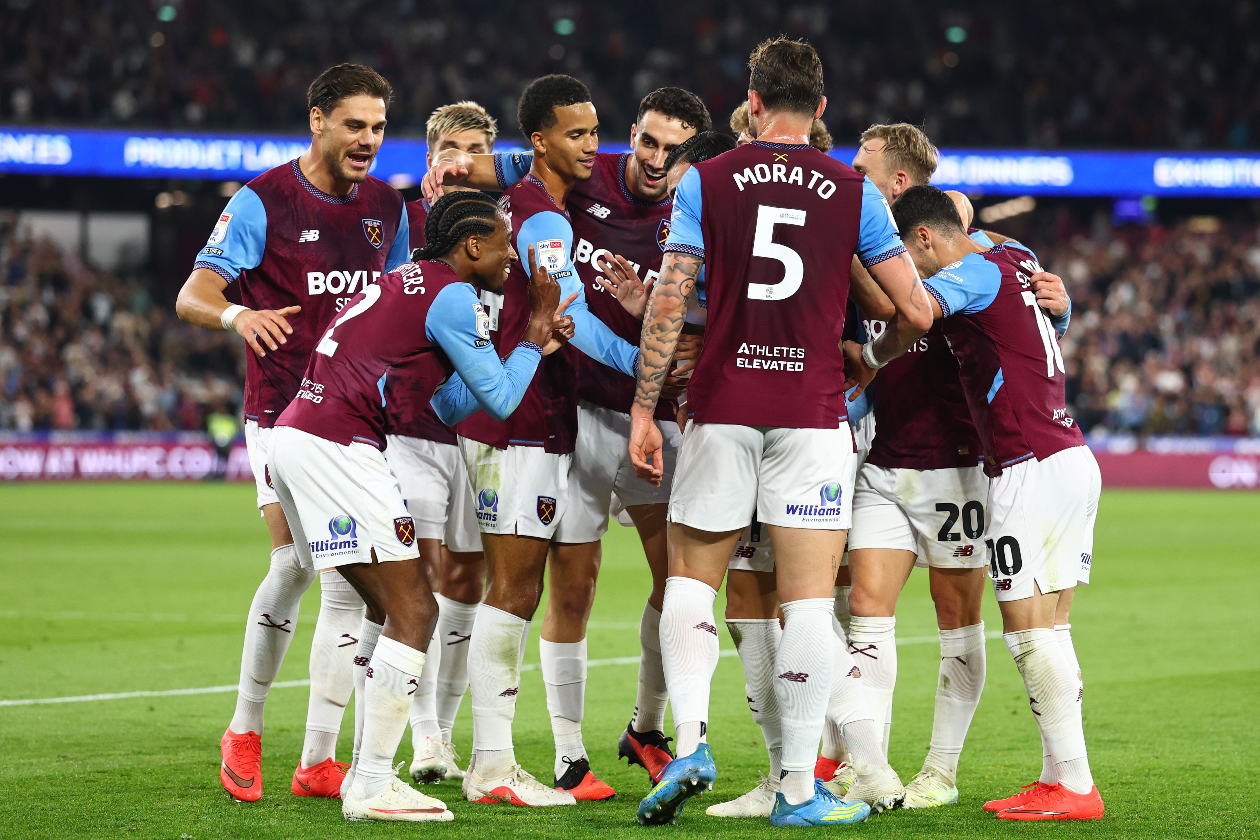 Several West Ham players celebrate a goal scored in their home kit 
