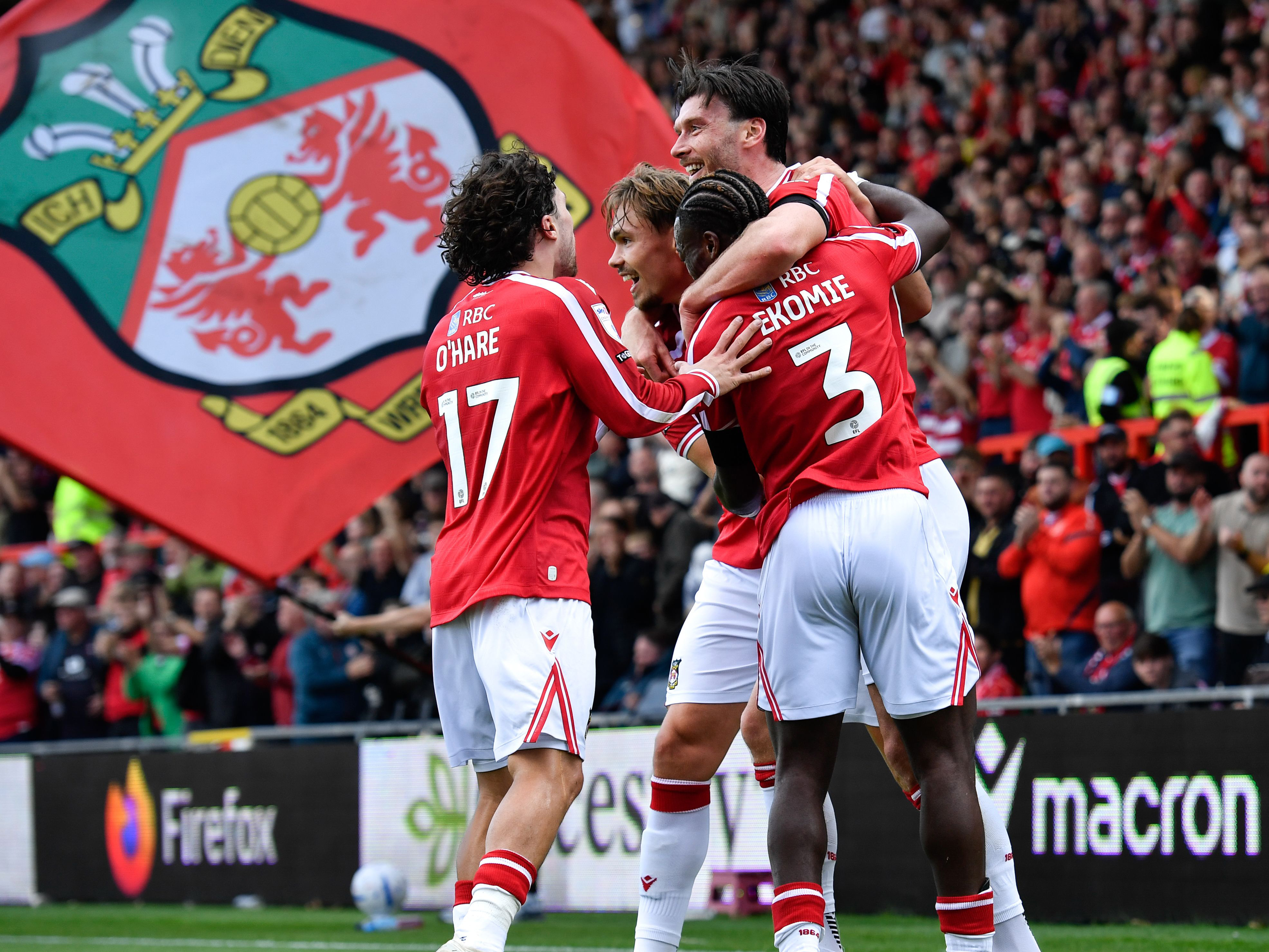 Wrexham players celebrating a goal scored in their home kit 