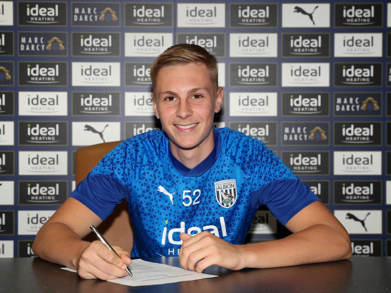 A photo of Layton Love signing his first professional contract