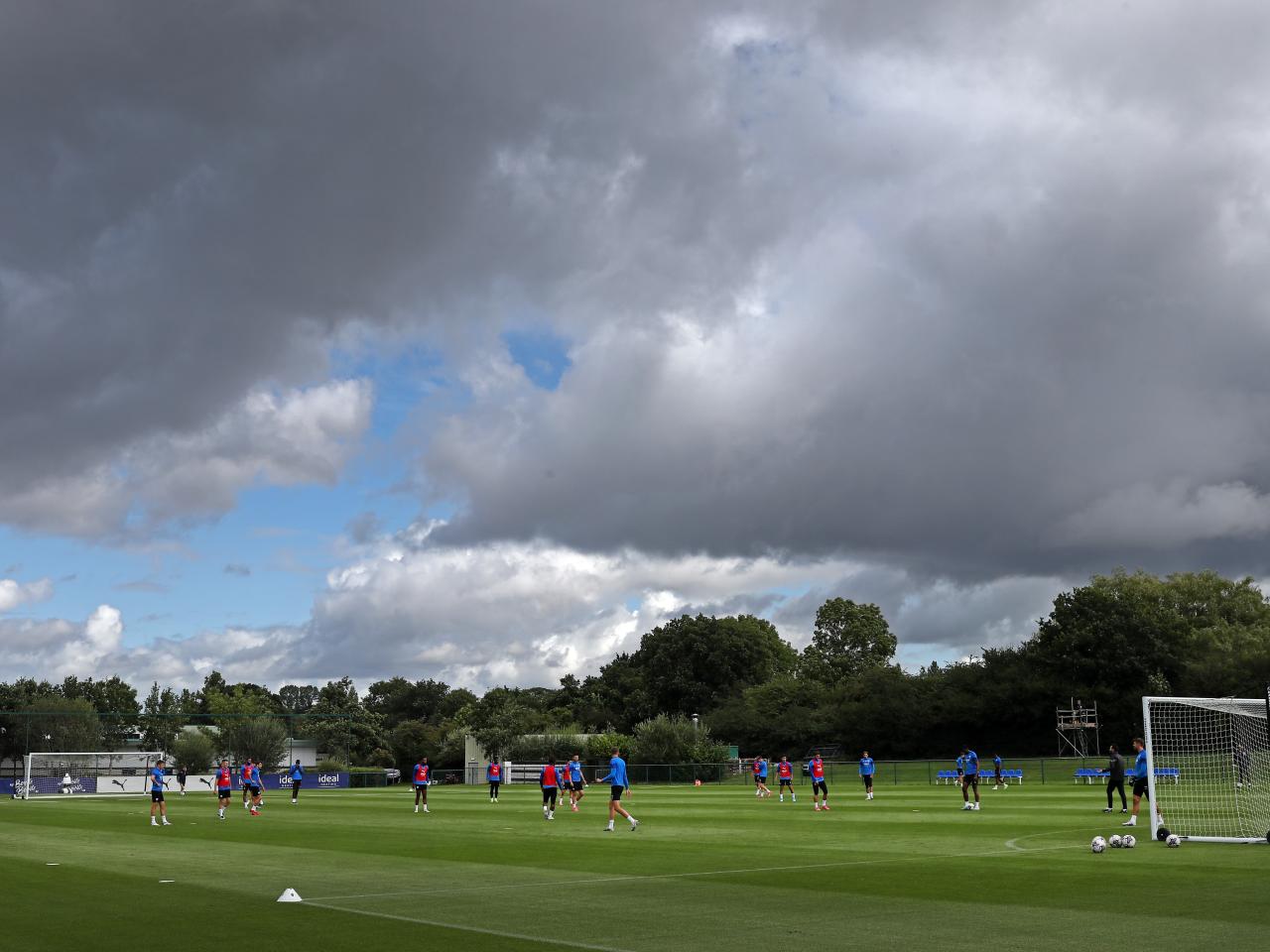 A wide angle of the training pitch with several players in the background