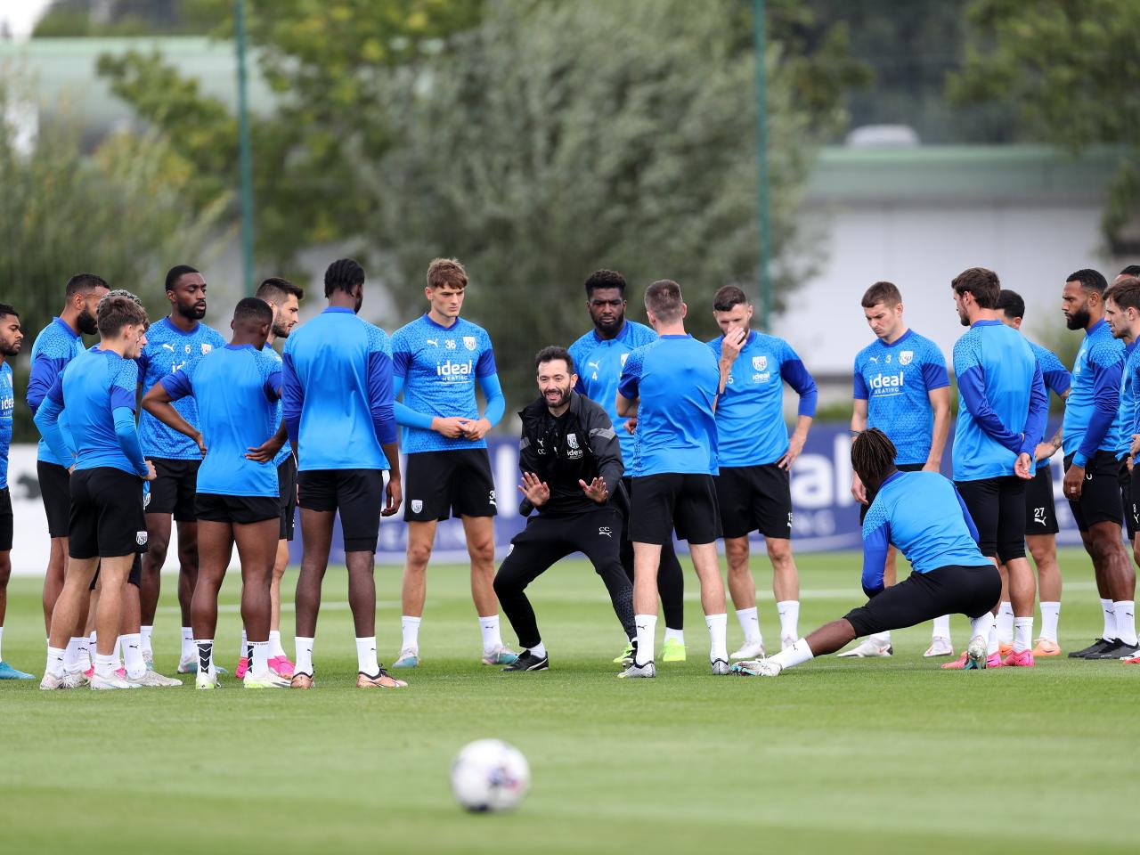 The players in a huddle on the training pitch with Carlos Corberán in the middle