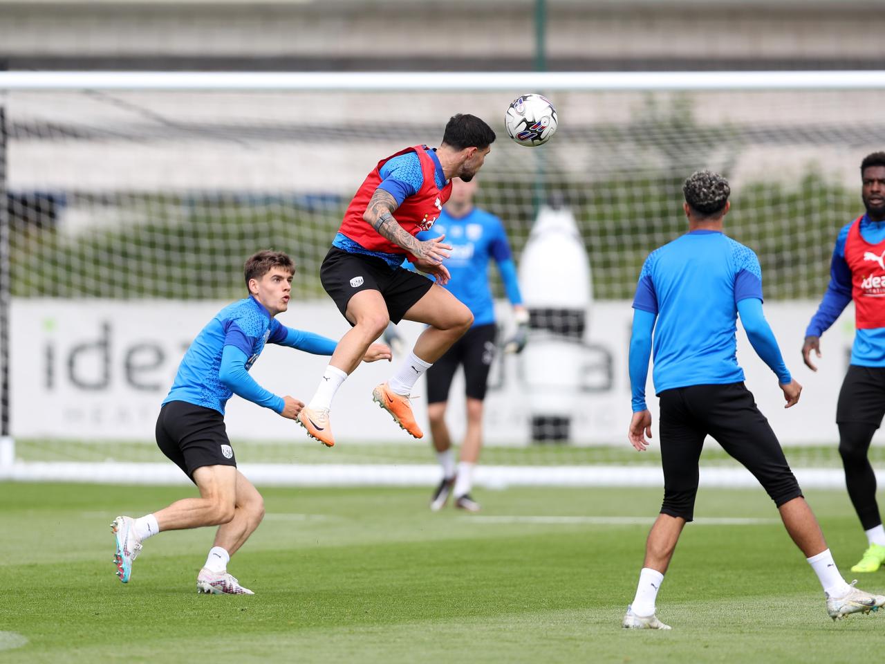 Alex Mowatt heads the ball in training 