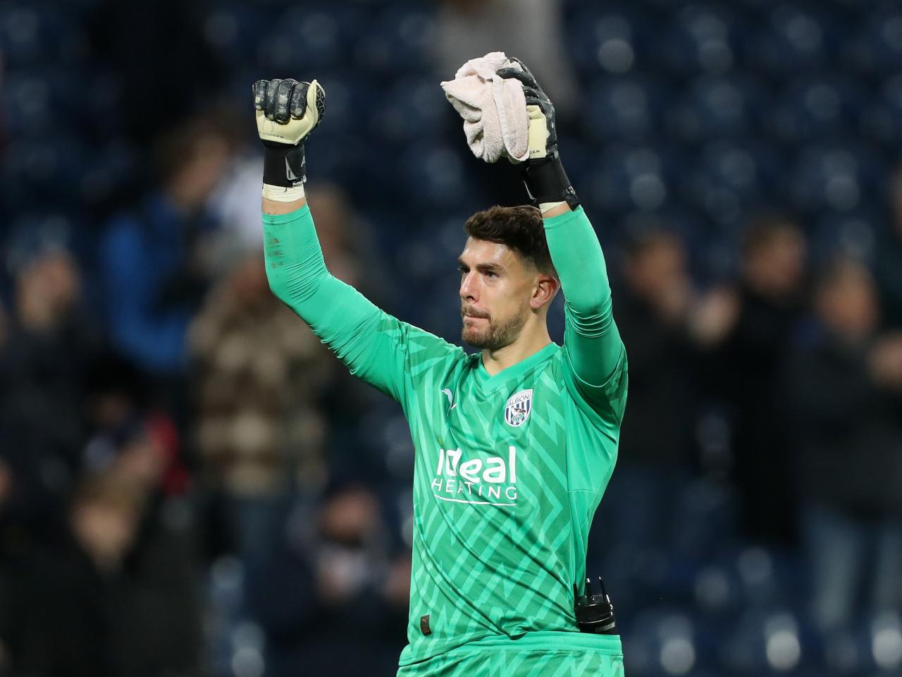 Alex Palmer celebrates with his arms in the air at full time
