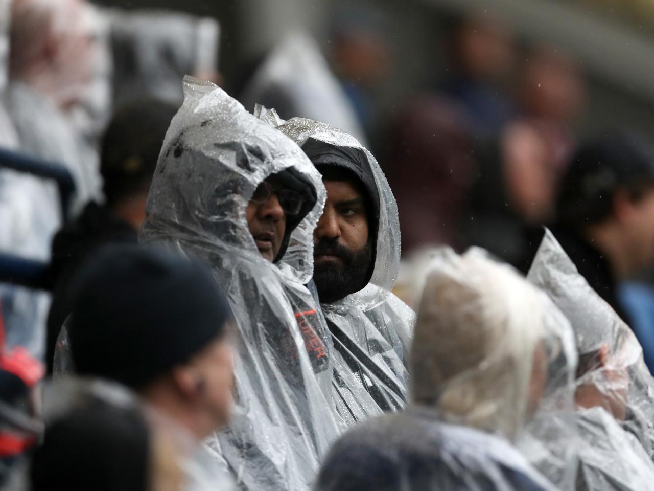 Two Albion fans stood in raincoats