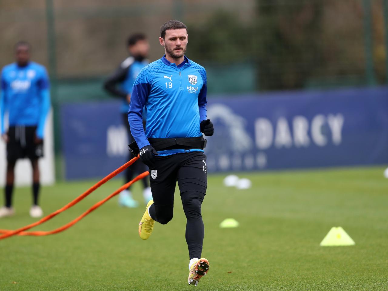 John Swift running with a parachute attached to his back