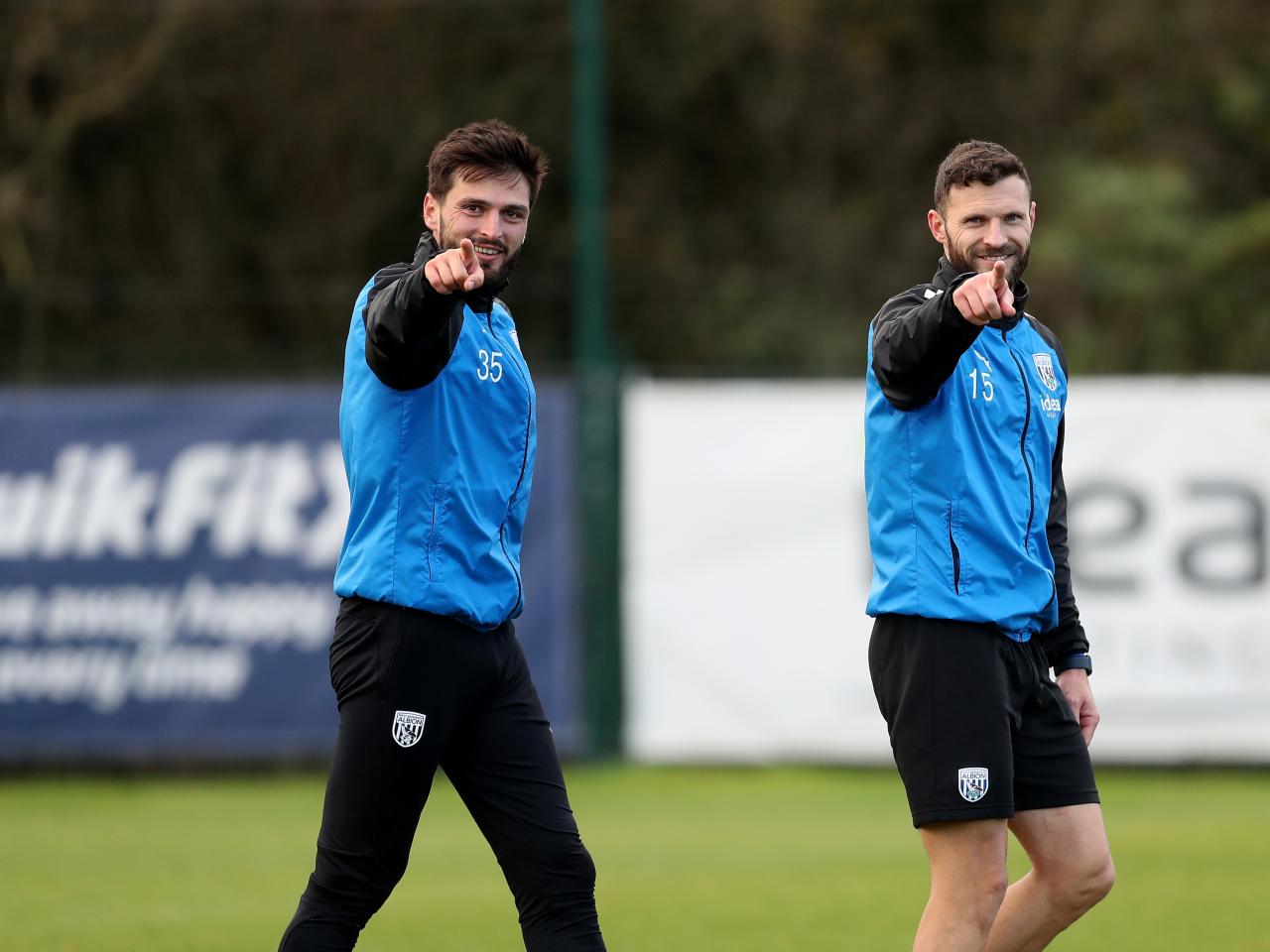 Okay Yokuslu and Erik Pieters pointing and smiling directly towards the camera
