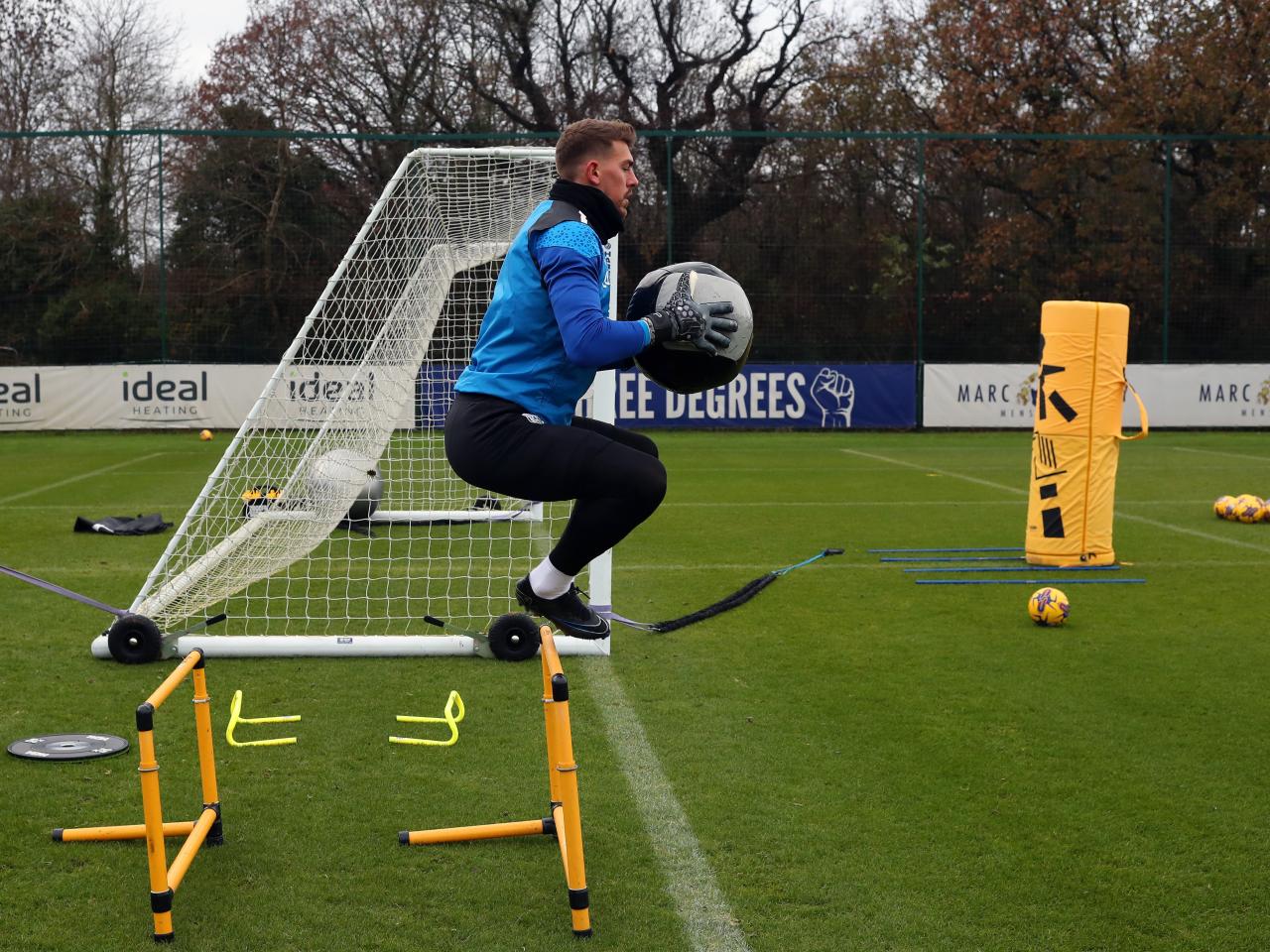 Alex Palmer jumping in the air while holding a big ball