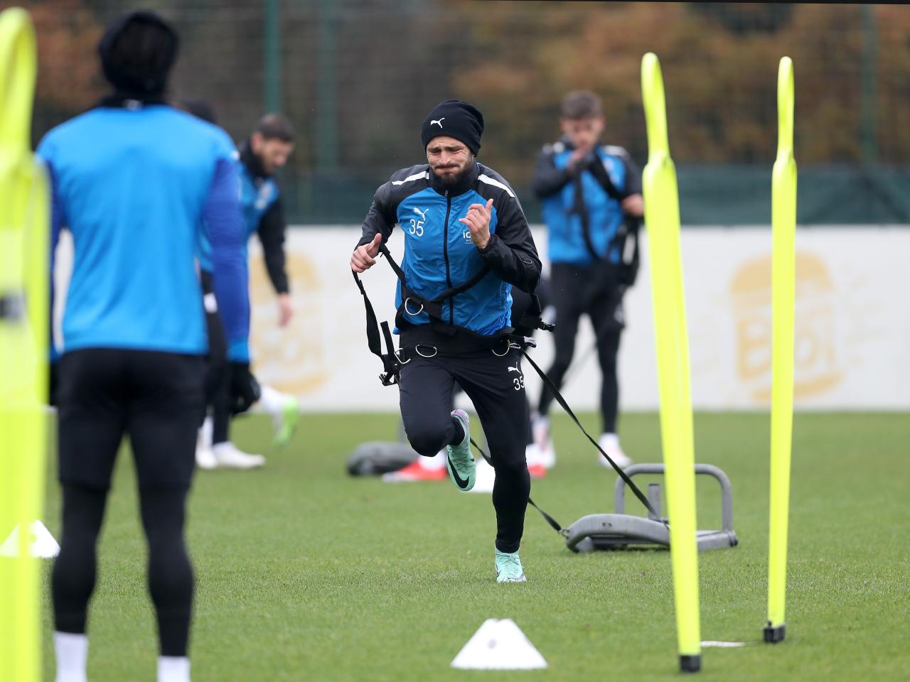 Okay Yokuslu running forward with a weight attached behind him