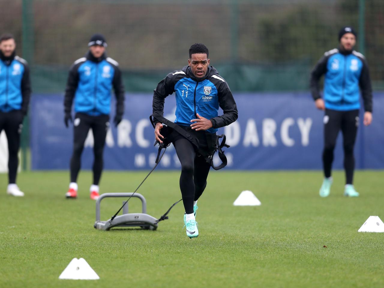 Grady Diangana running forward with a weight attached behind him