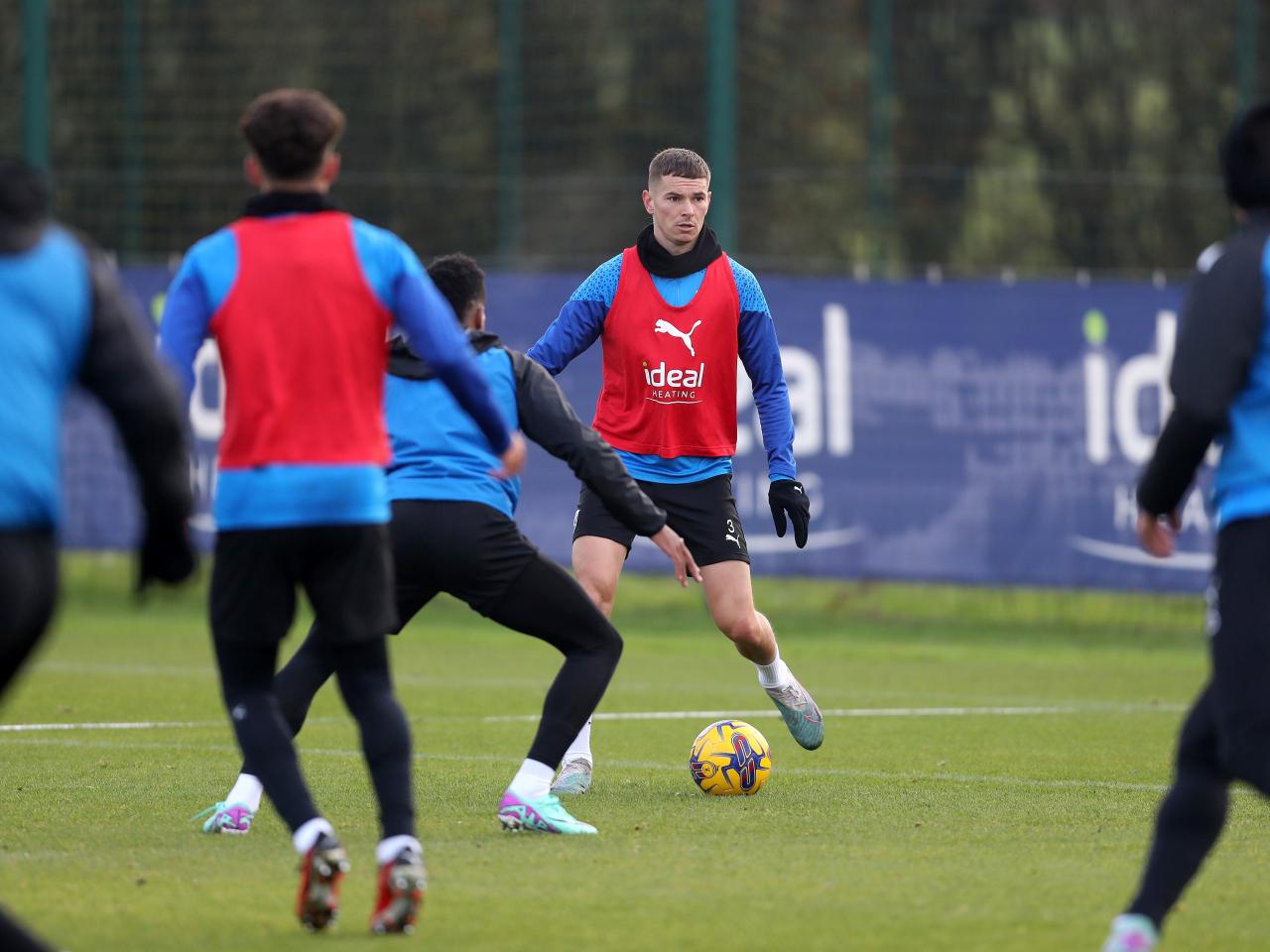 Conor Townsend on the ball in training while wearing a red bib