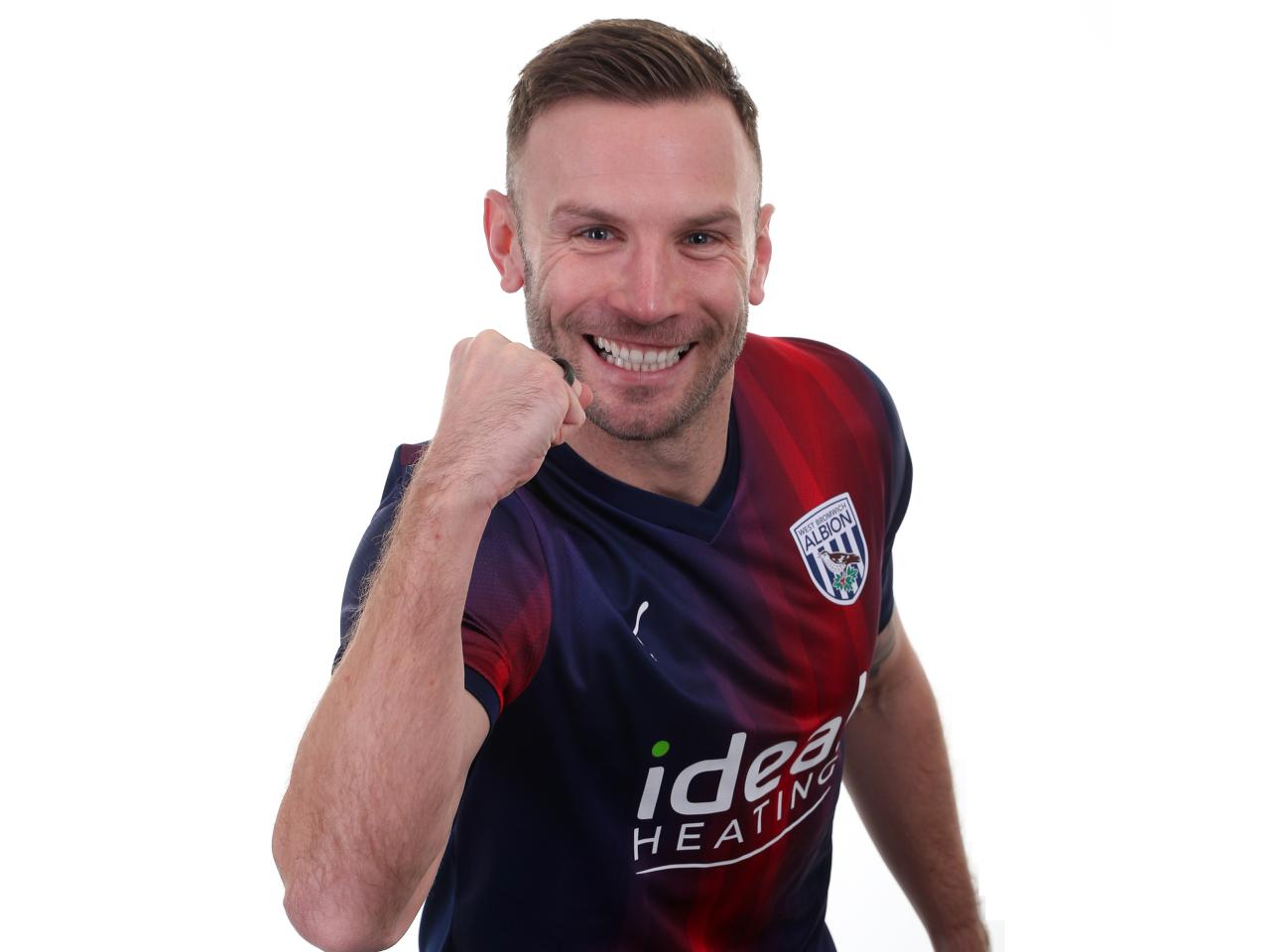 Andi Weimann celebrating to camera in the red and blue away kit