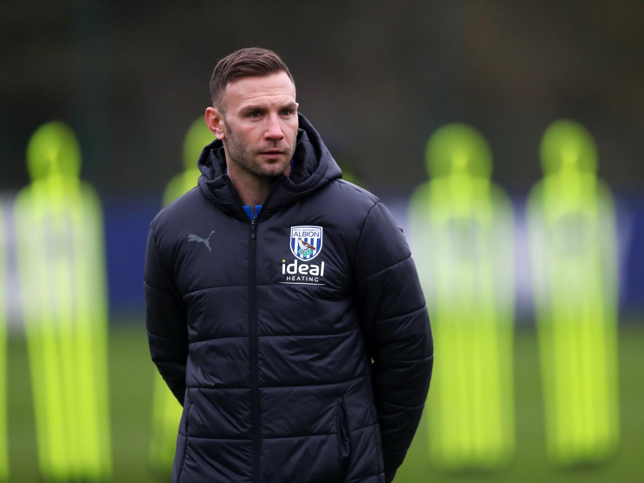 Andi Weimann watching training in a black coat