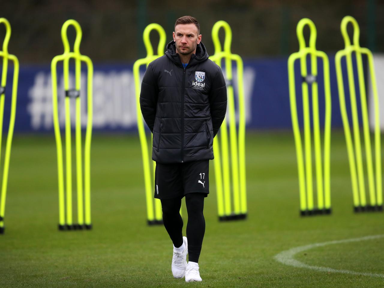 Andi Weimann watching training in a black coat