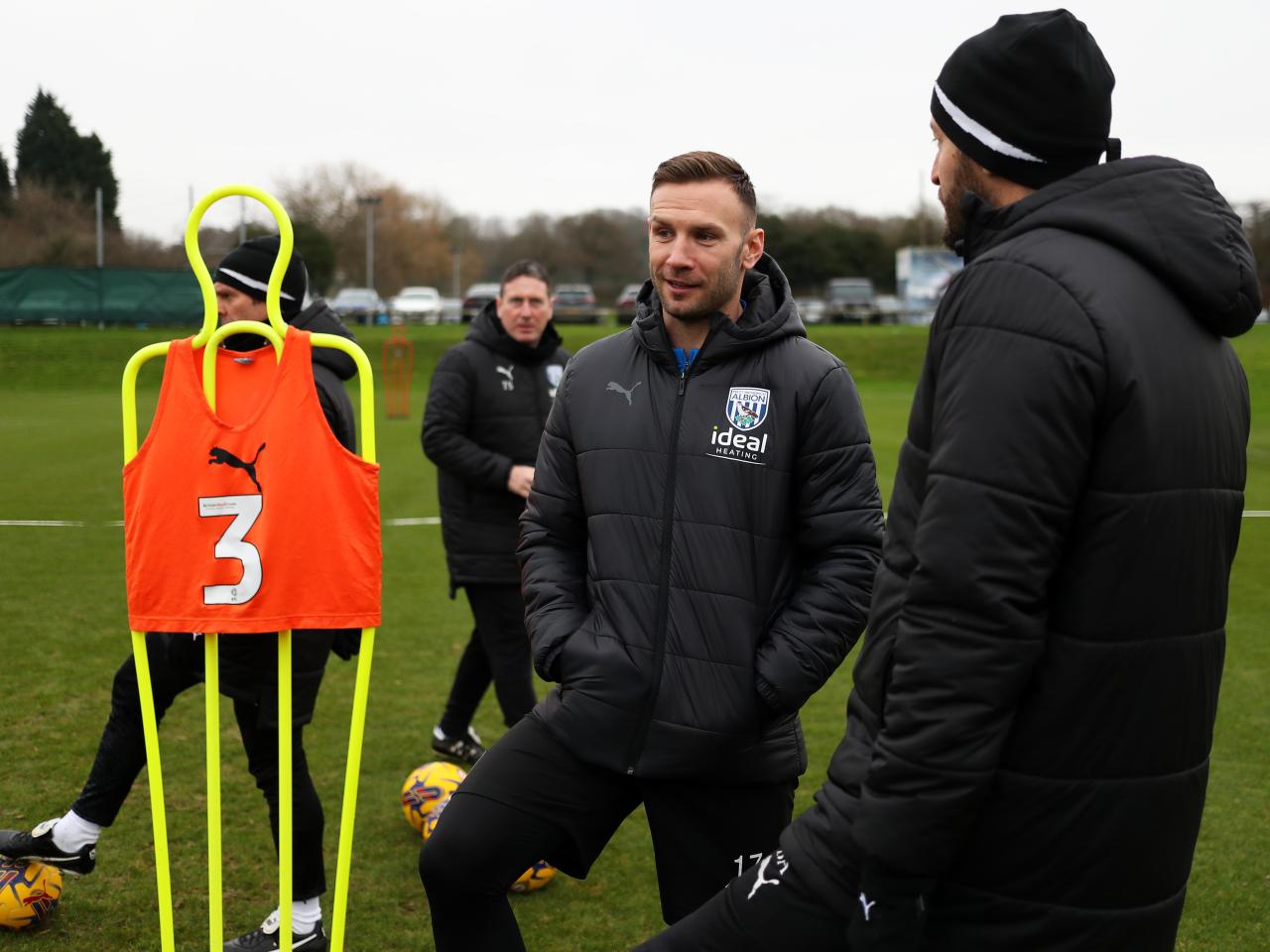 Andi Weimann smiling talking to Albion staff out on the training pitch