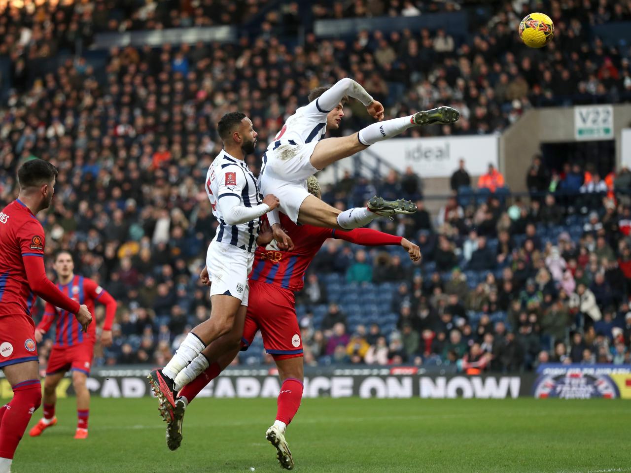 Caleb Taylor jumping high for the ball against Aldershot