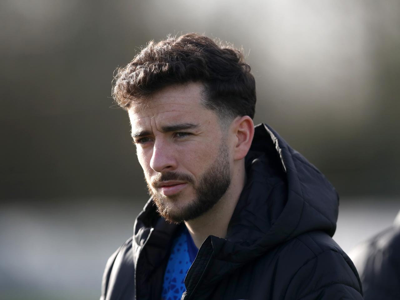 Mikey Johnston watching a training session wearing a big Albion coat