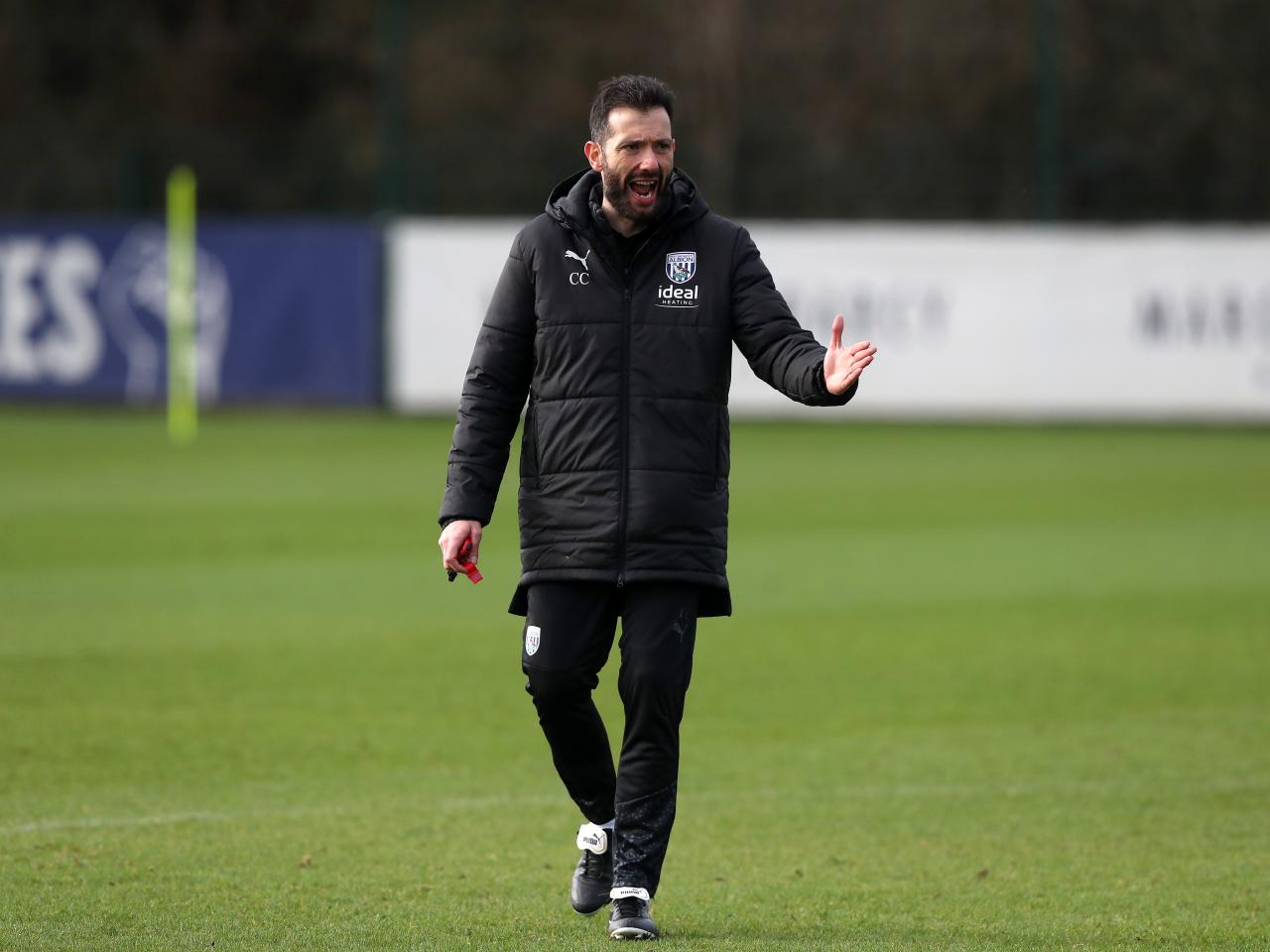 Carlos Corberán wearing a black coat during a training session