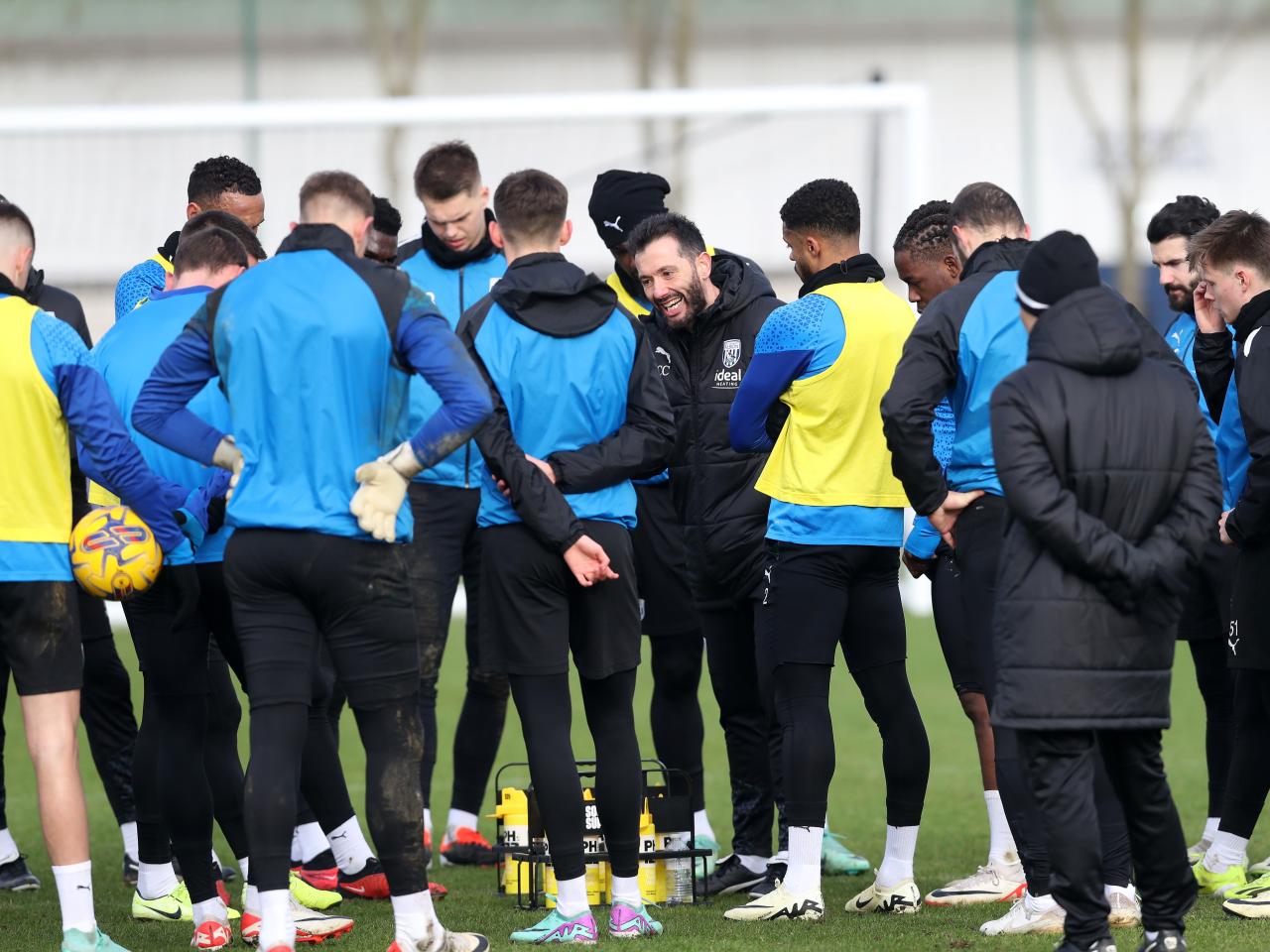 Carlos Corberán delivering instructions to several players during a training session