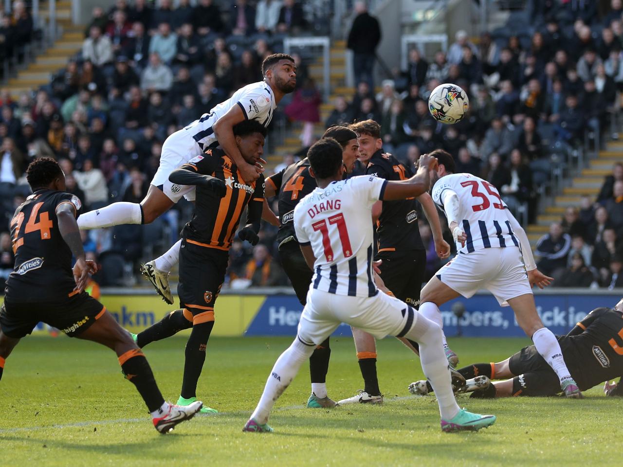 Albion and Hull players battle for the ball in the air in the penalty area