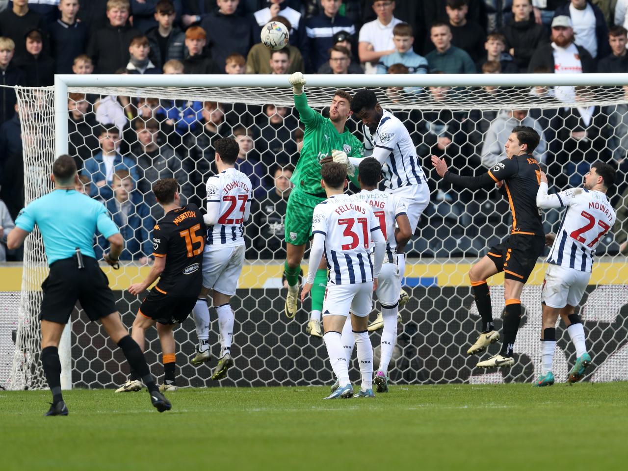 Alex Palmer punches the ball clear with several Hull and Albion players around him