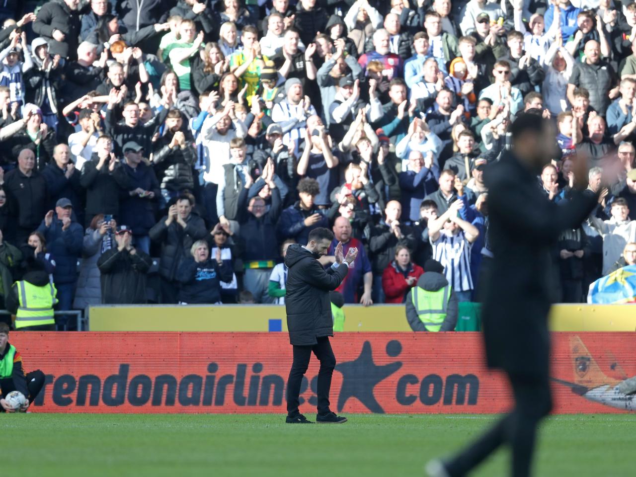 Carlos Corberán applauding Albion fans in the background at the MKM Stadium