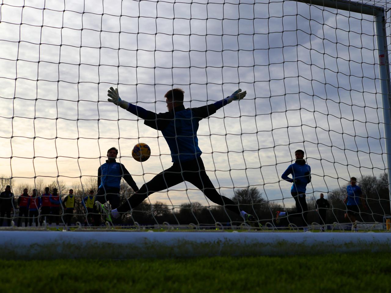 a view from behind a goal net during a training session