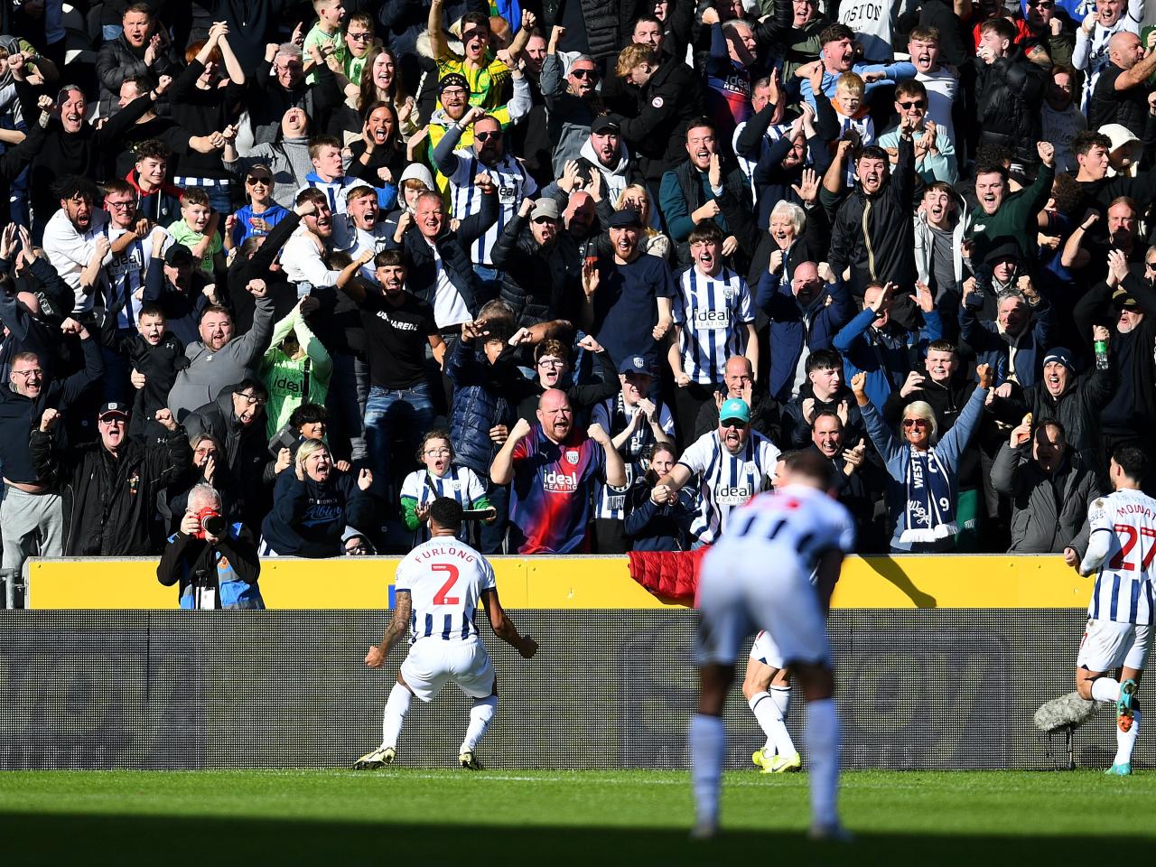 Darnell Furlong celebrates his goal against Hull with Albion fans in front of him