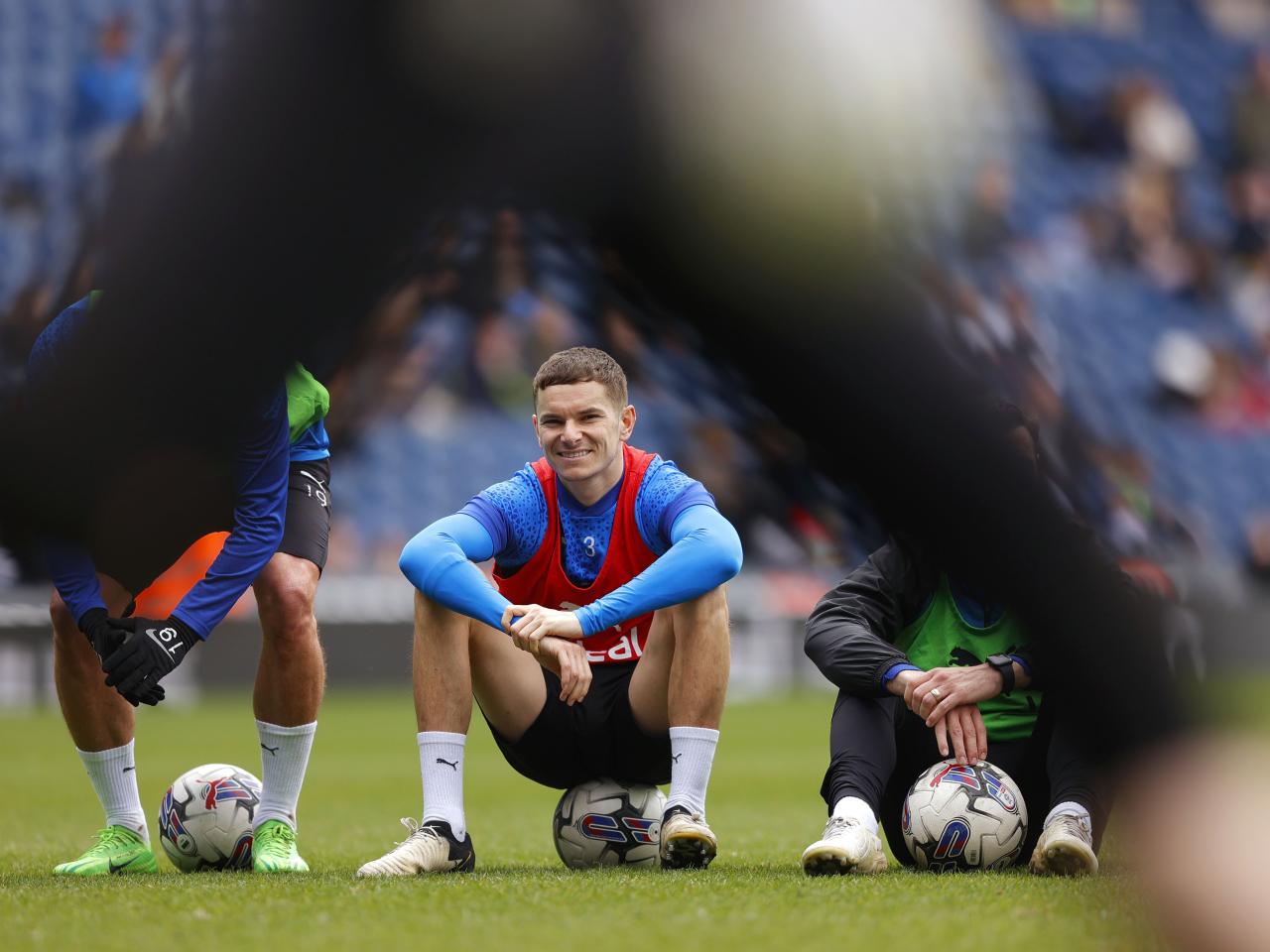 Conor Townsend sat on a ball smiling during a training session at The Hawthorns