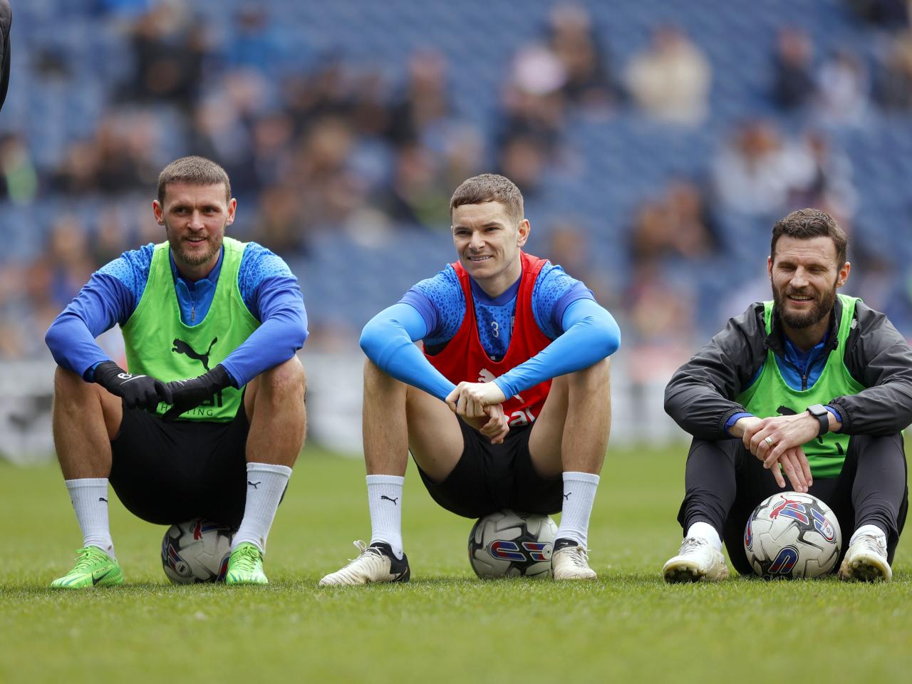 John Swift, Conor Townsend and Erik Pieters sat down smiling while watching training at The Hawthorns
